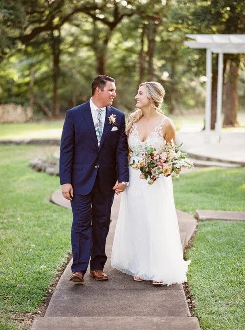 Groom in navy suite with brown shoes at at Outdoor wedding ceremony