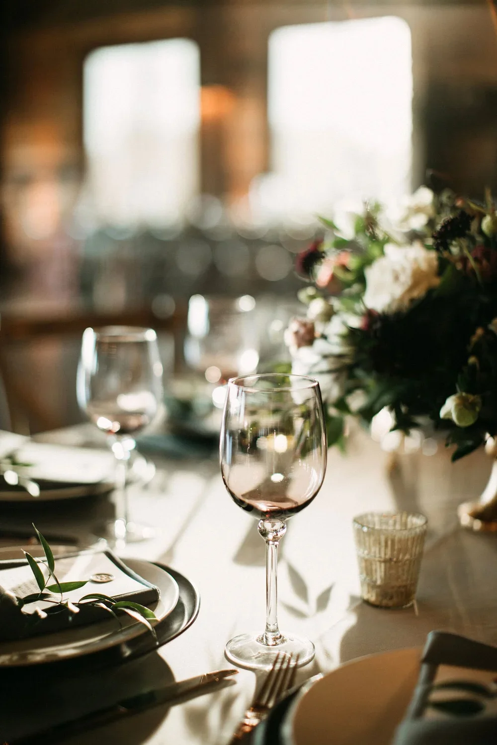 Moody wedding table setting with purple glassware &amp; black chargers