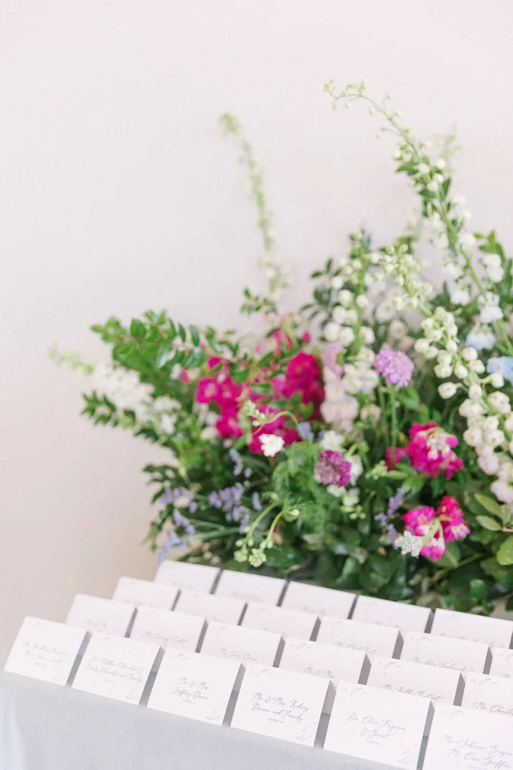 Seating Chart with folded escord cards on a velvet linen with pink flowers