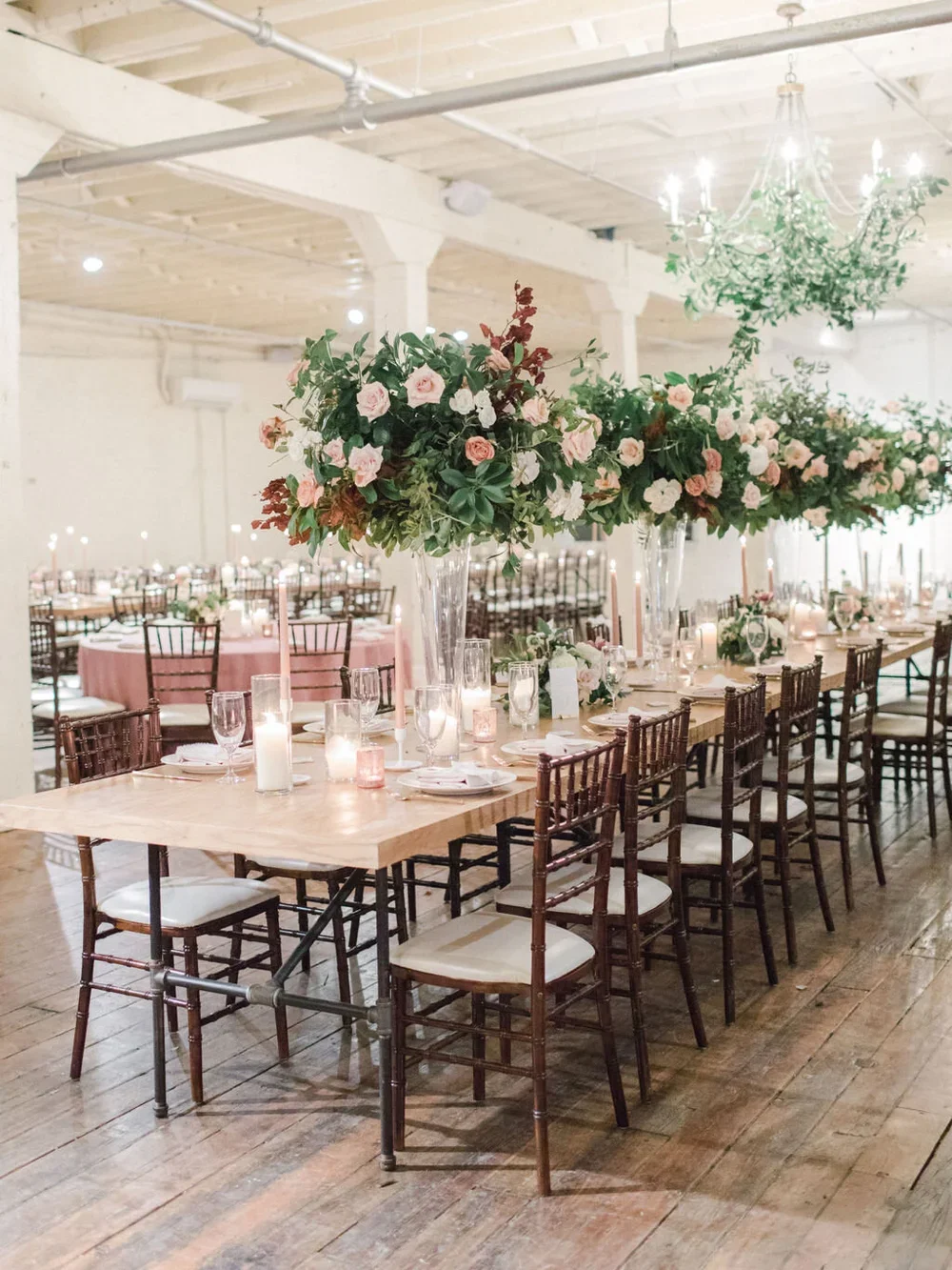 Tall peach, orange &amp; pink flower arrangements on a wood farm table