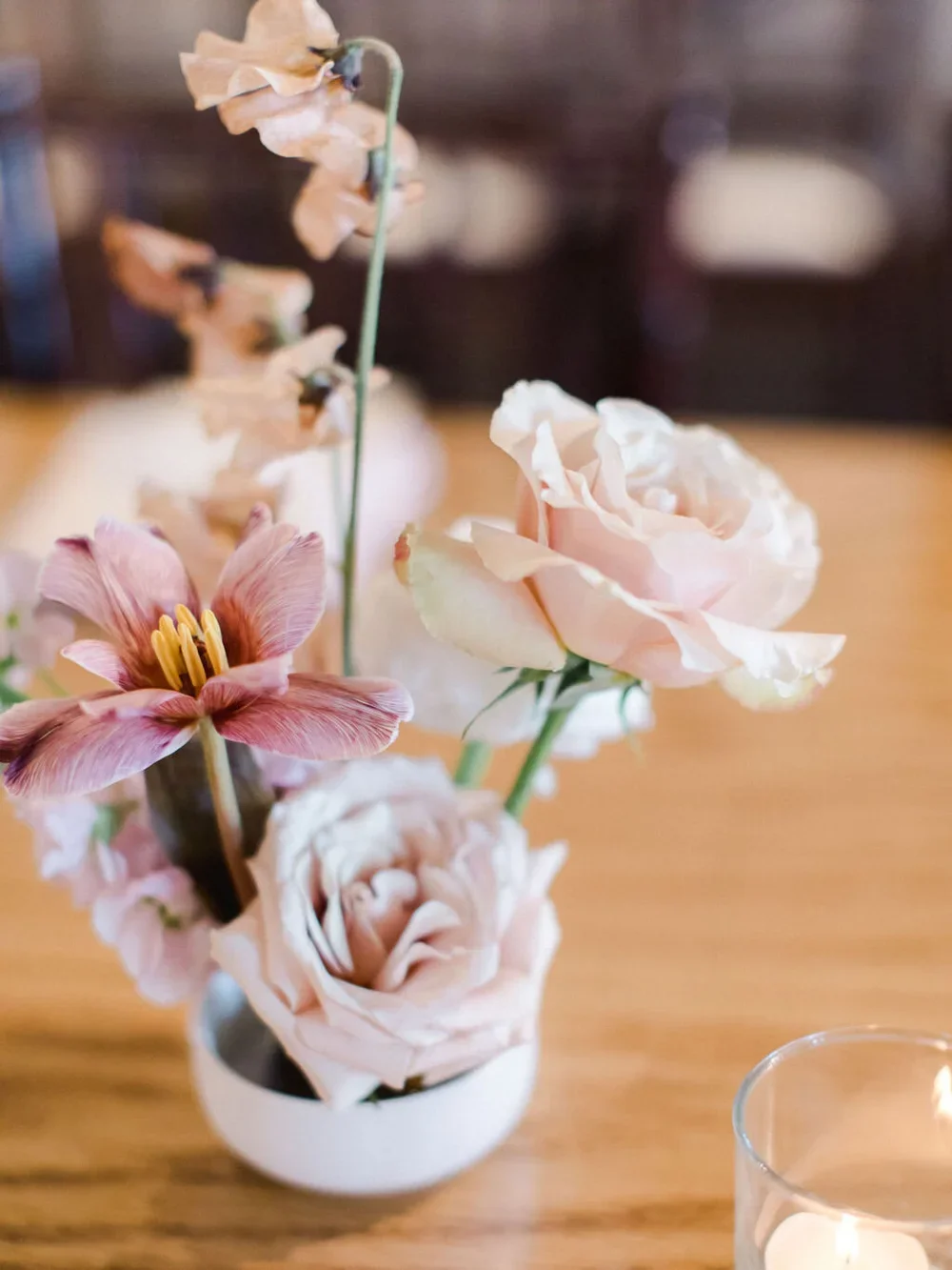 Pink tulip and sweet peas in white frog container