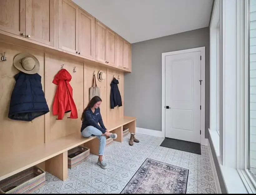 Woman using a custom mudroom built-in by Mink Run Millwork