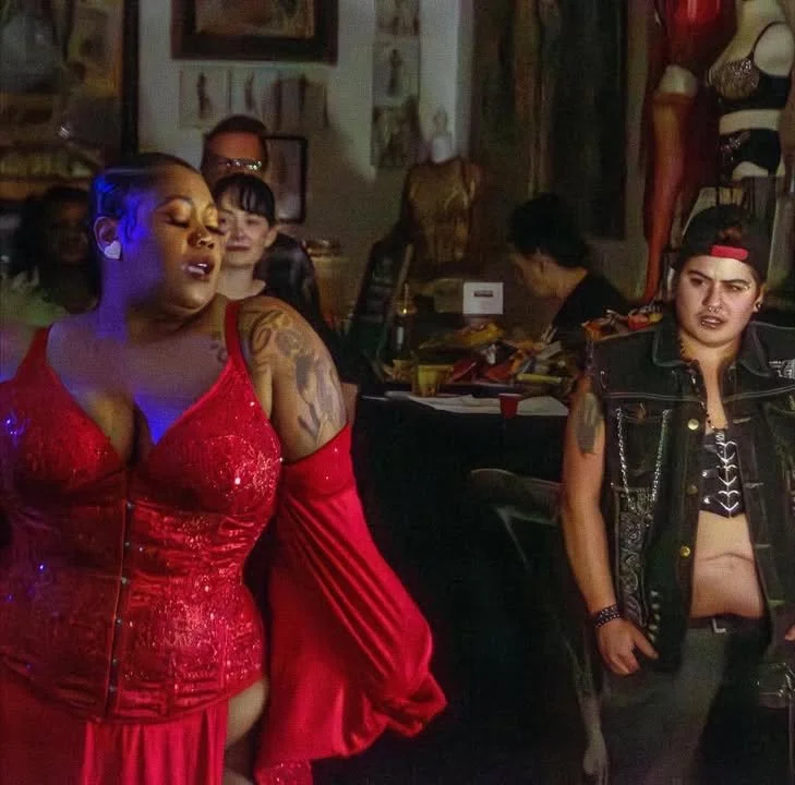 Harlem Nyte performing in front of a crowd at Ecdysiast Arts Museum in a red burlesque costume.