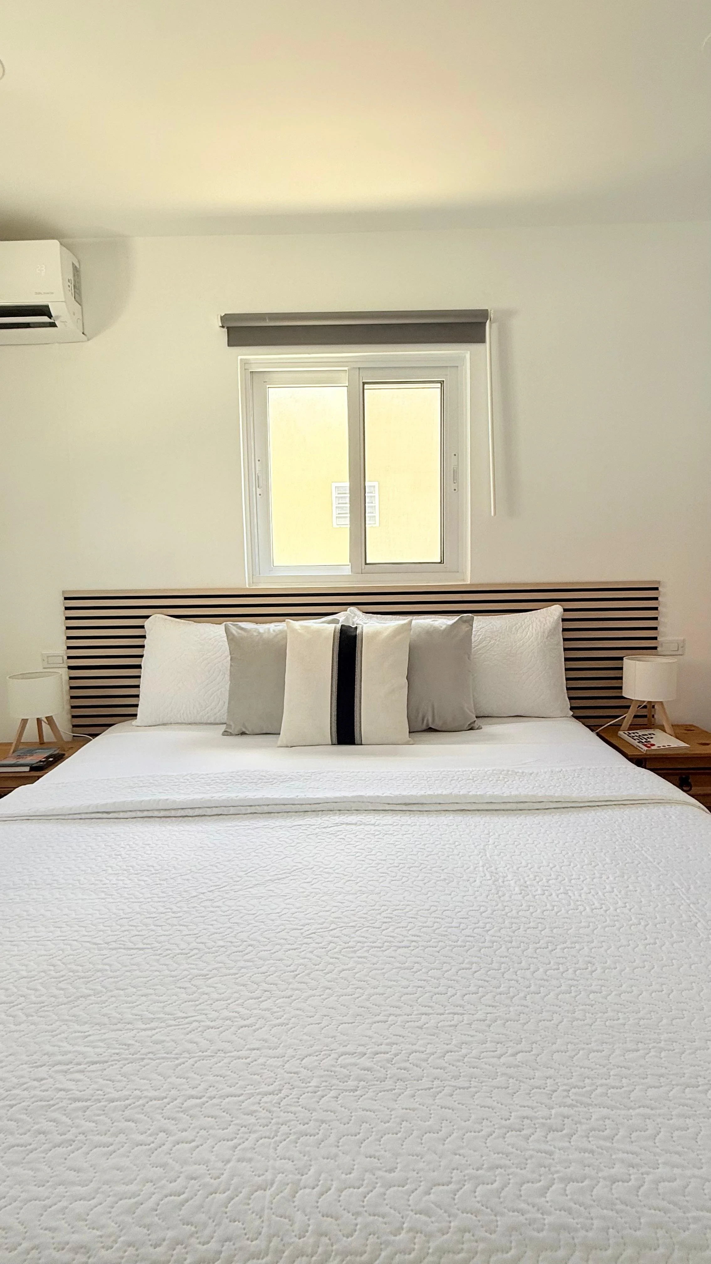 Kas Pitava, Bonaire, King-size bed with crisp white linens and elegant grey accents.