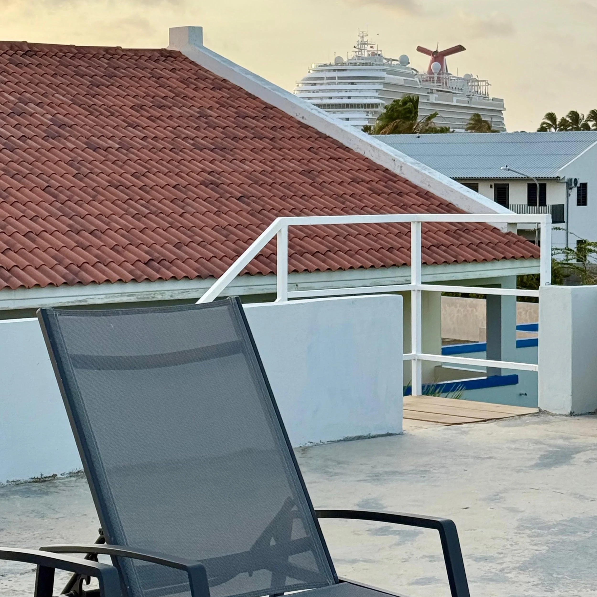 Terrace lounge chair with red roof and Cruise ship view at Kas Pitava