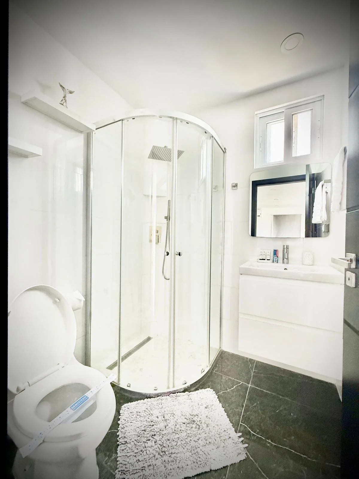 Modern bathroom with glass shower cabin and clean white design at Kas Pitava.