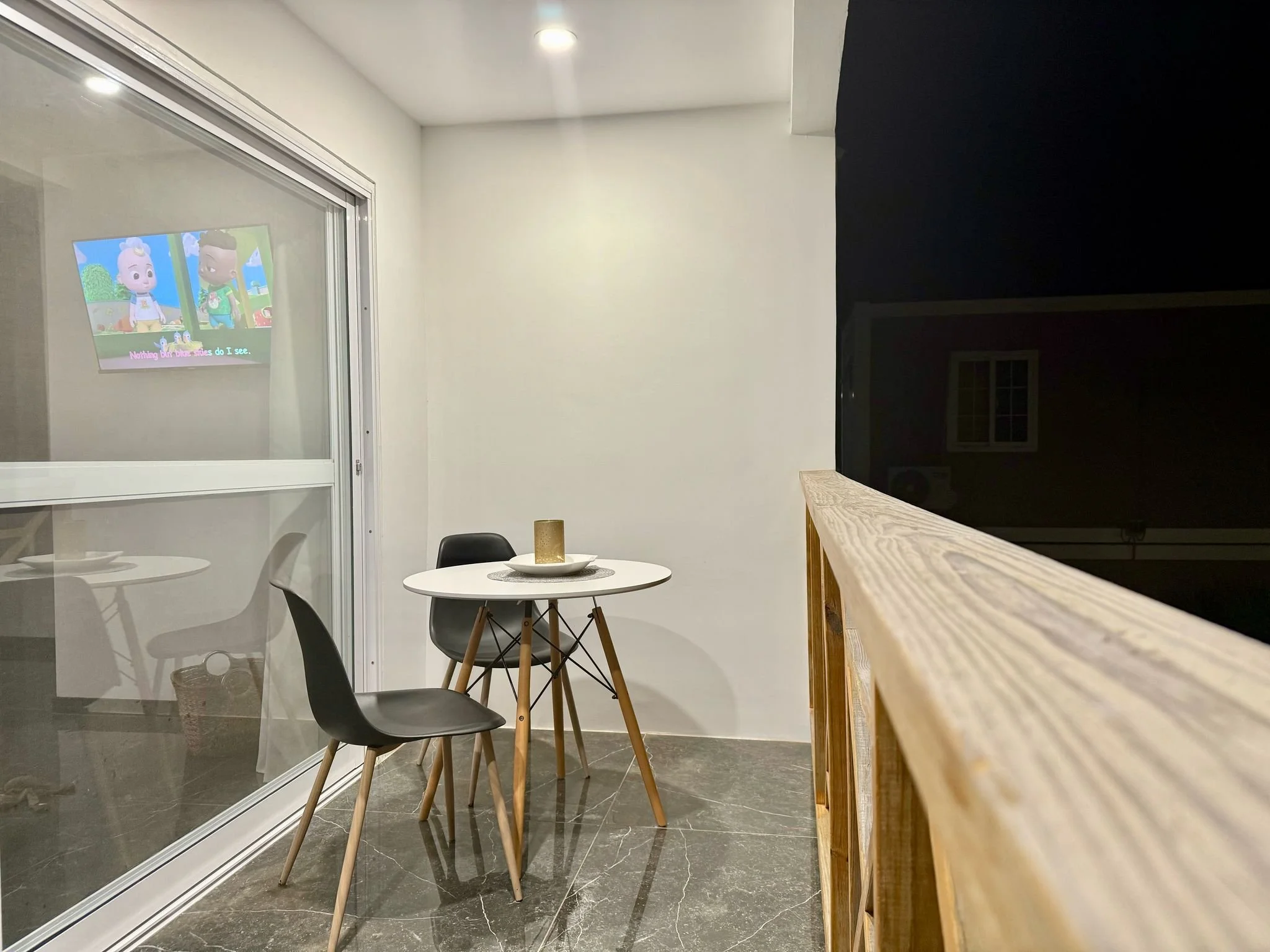 Stylish outdoor dining corner with modern black chairs and a view toward the terrace.