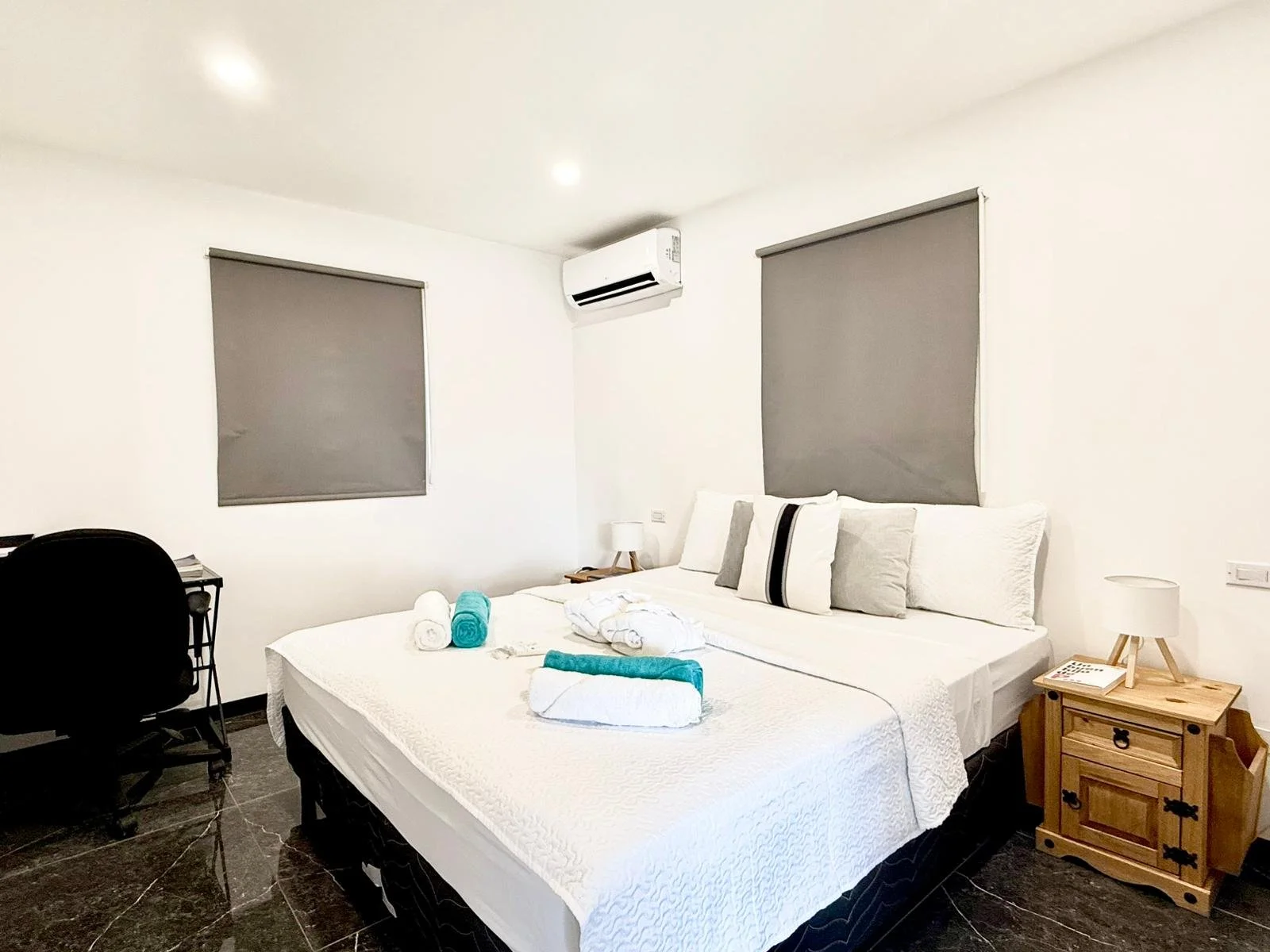 Kas Pitava, Bonaire, King-size bed with crisp white linens and elegant grey accents.