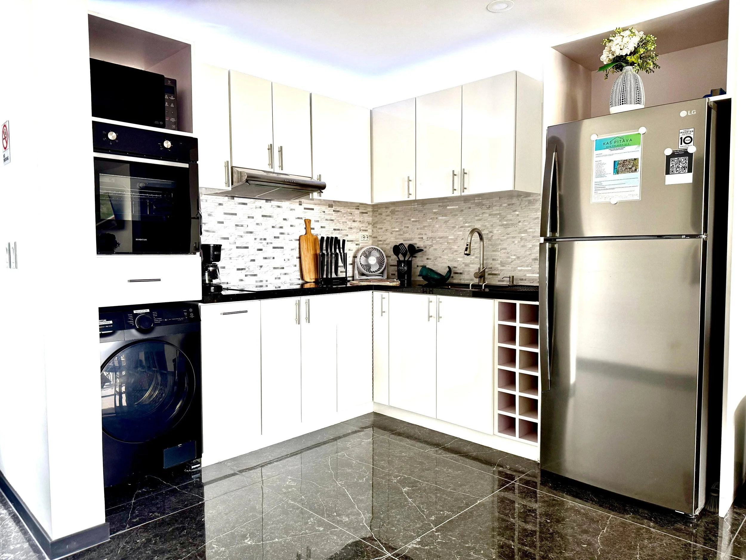 Fully equipped modern kitchen at Kas Pitava with tiled backsplash and stainless steel appliances.