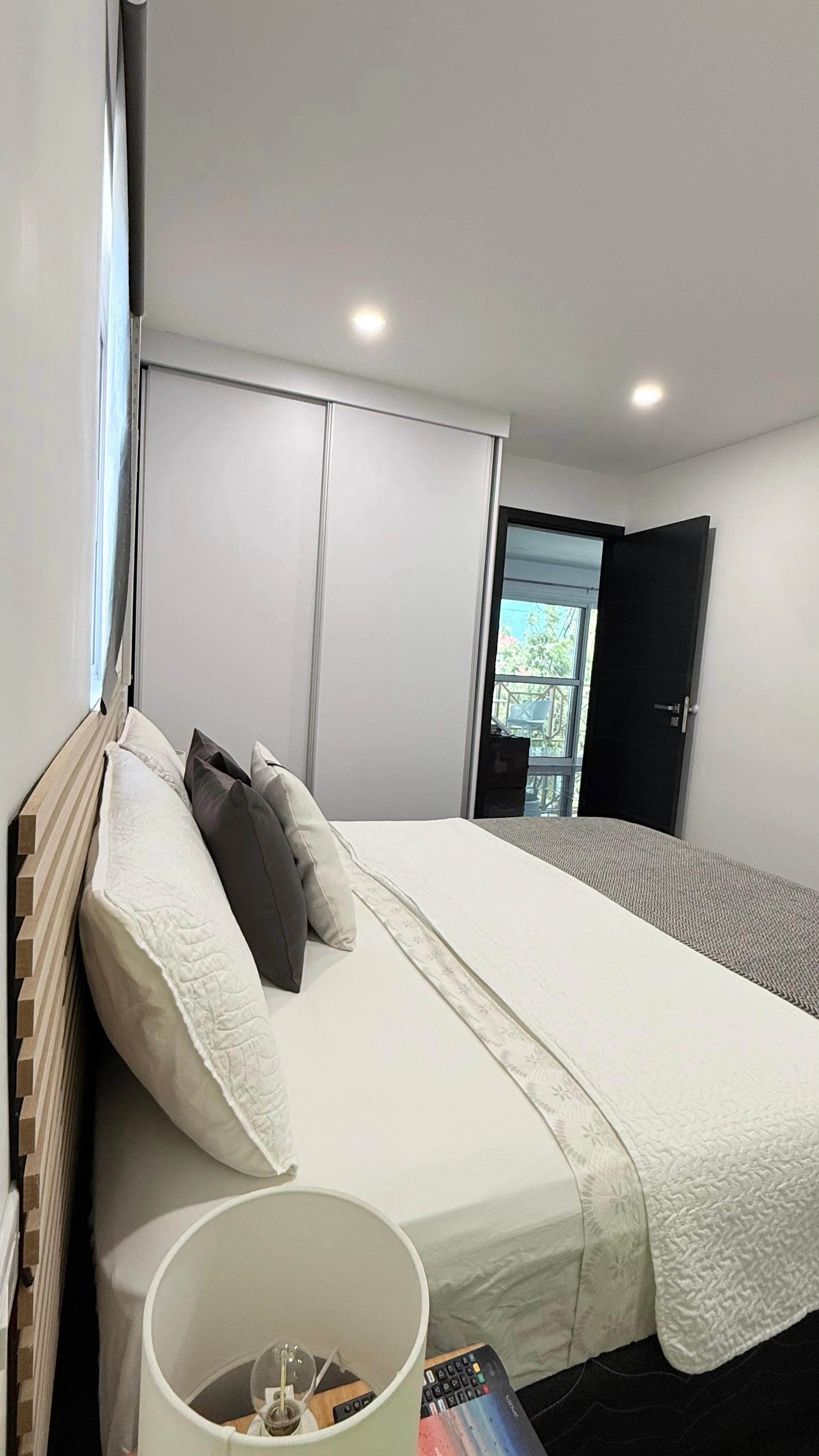 Kas Pitava, Bonaire, King-size bed with crisp white linens and elegant grey accents.
