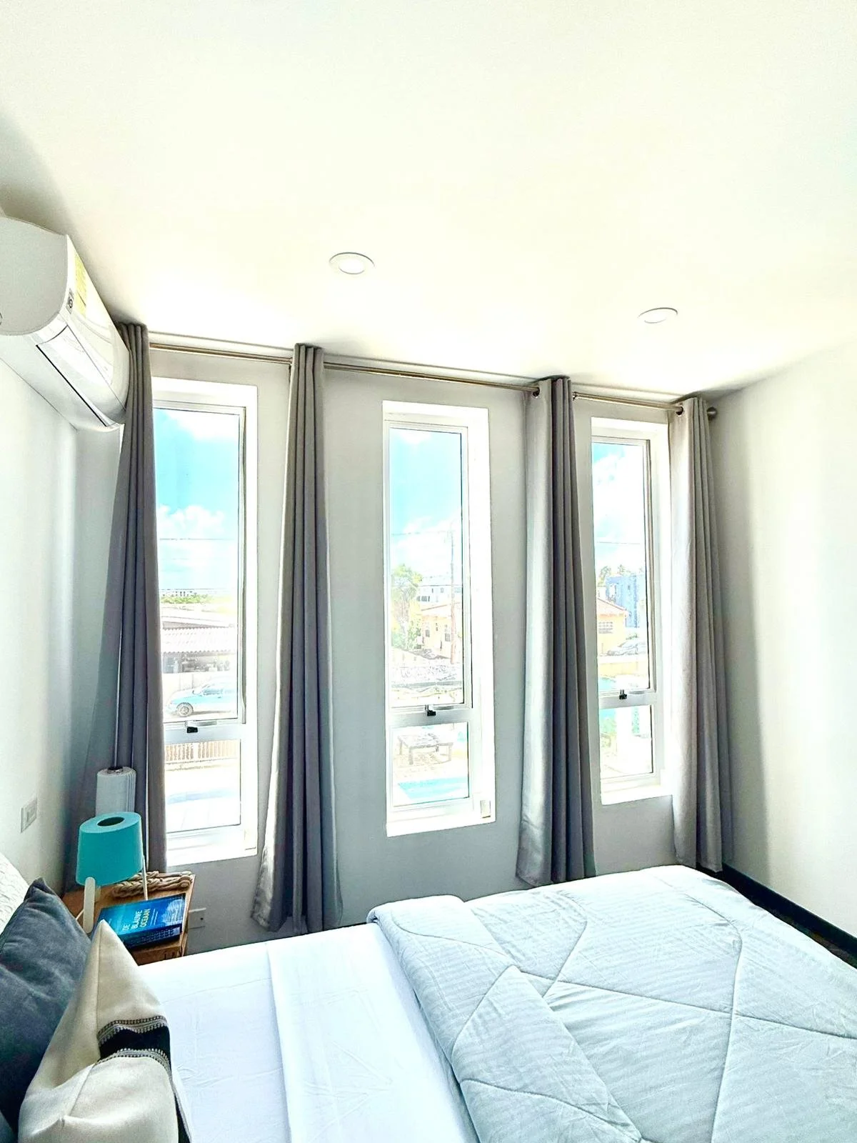 Modern guest room with full-size bed and wall-mounted TV at Kas Pitava.