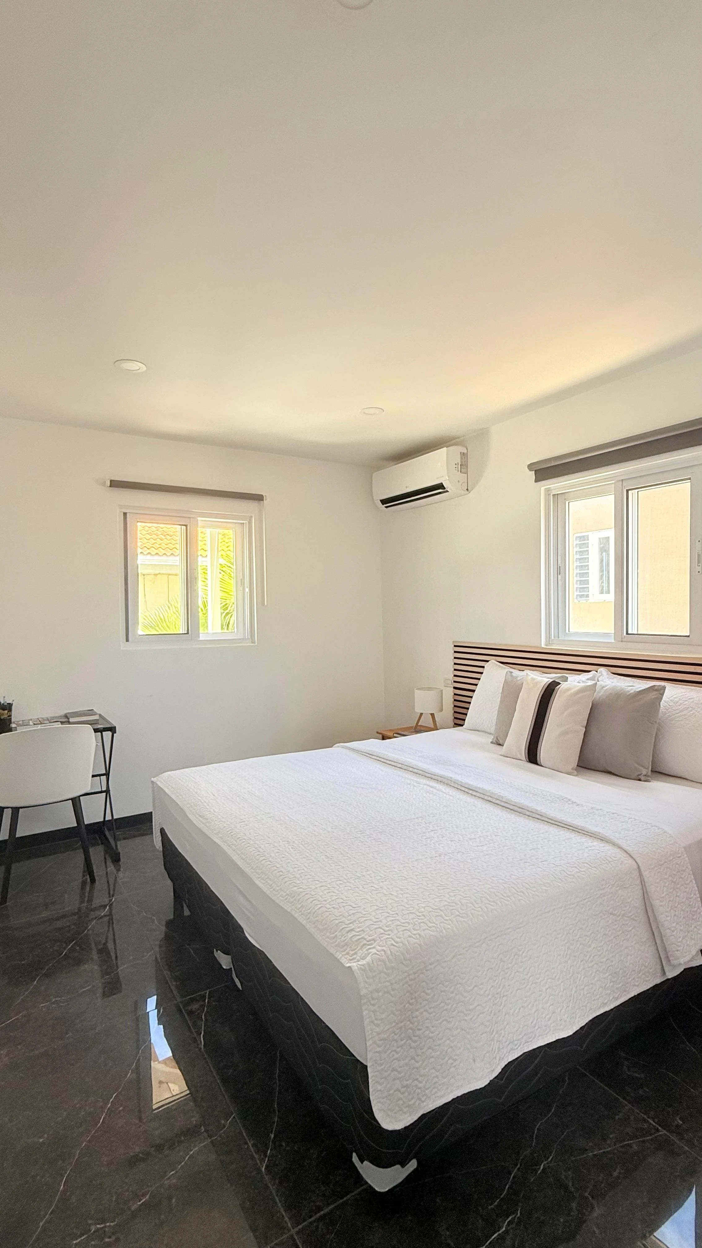 Kas Pitava, Bonaire, King-size bed with crisp white linens and elegant grey accents.