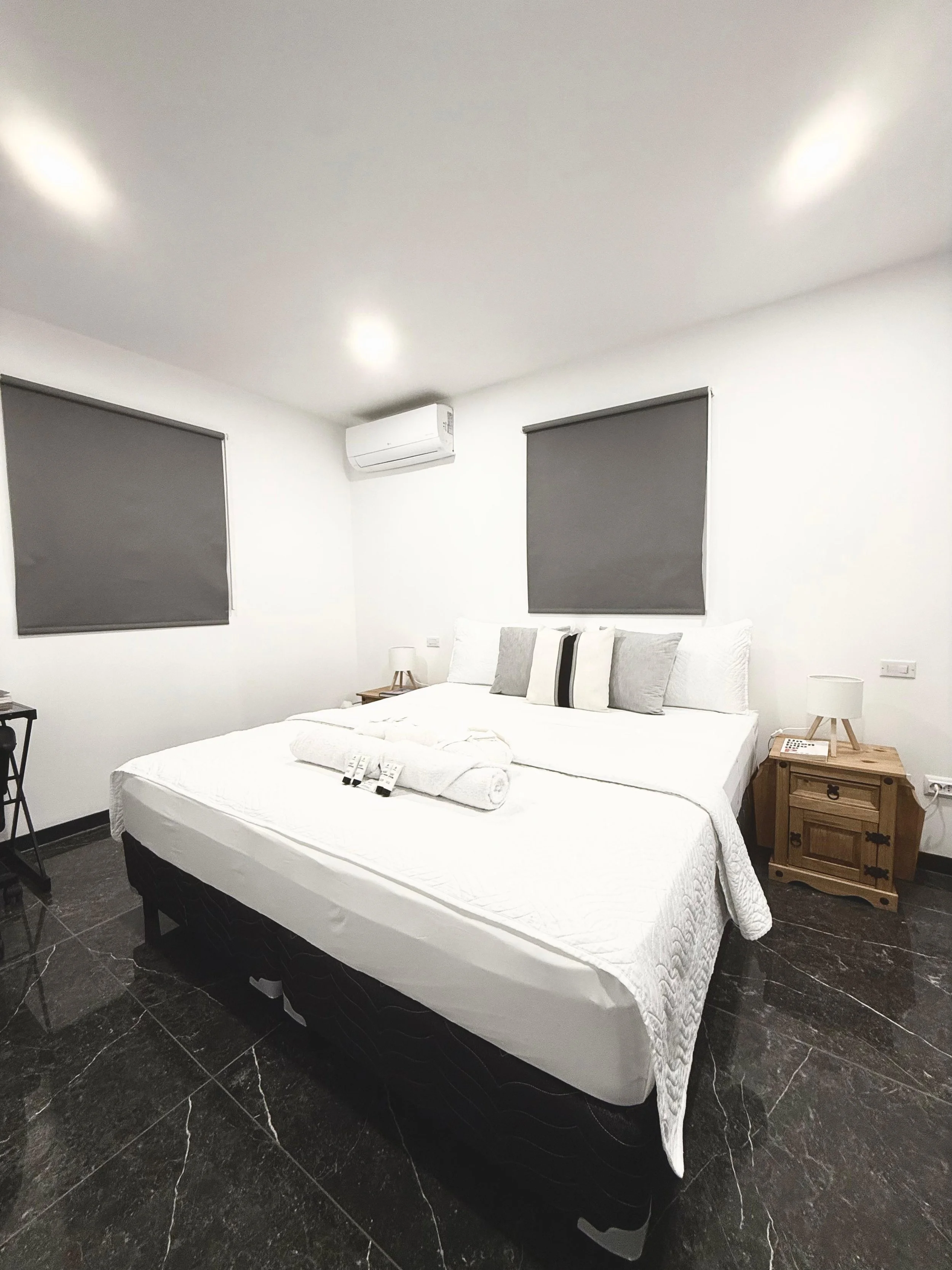 Kas Pitava, Bonaire, King-size bed with crisp white linens and elegant grey accents.