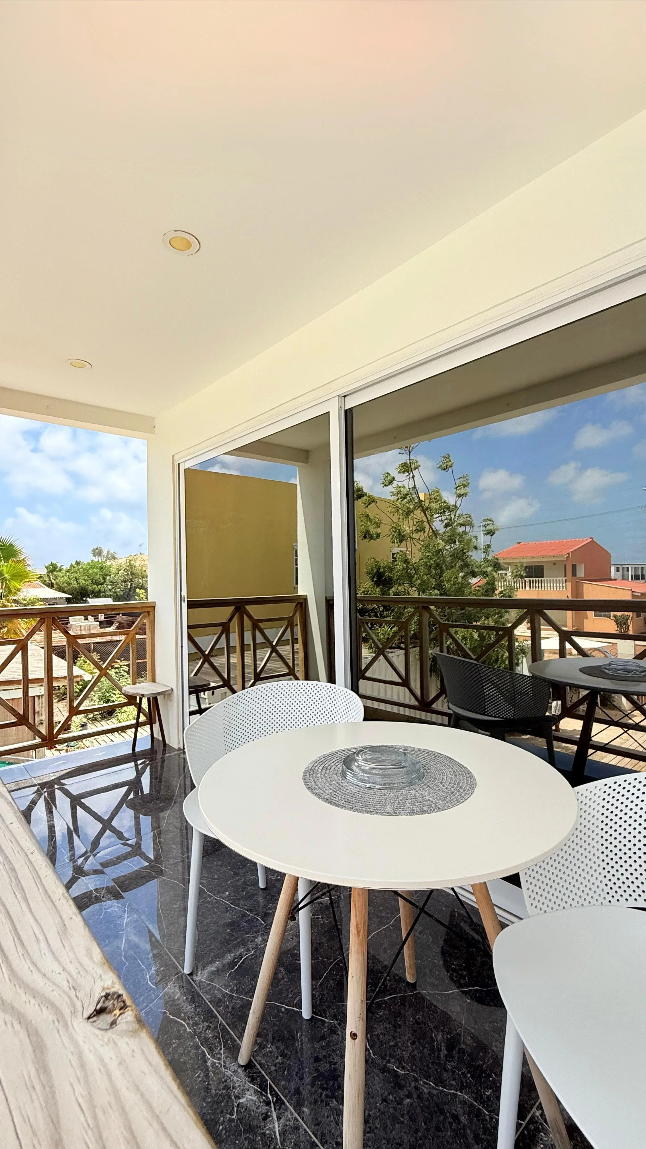 Stylish outdoor dining corner with modern white chairs and a view toward the terrace.