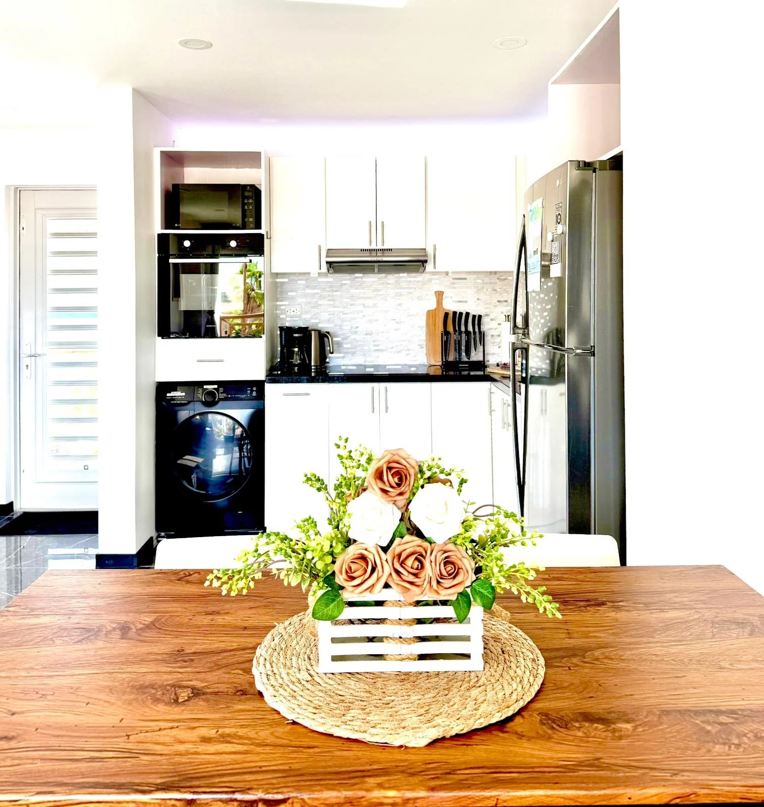 Fresh flowers and welcome amenities on the wooden dining table at Kas Pitava.