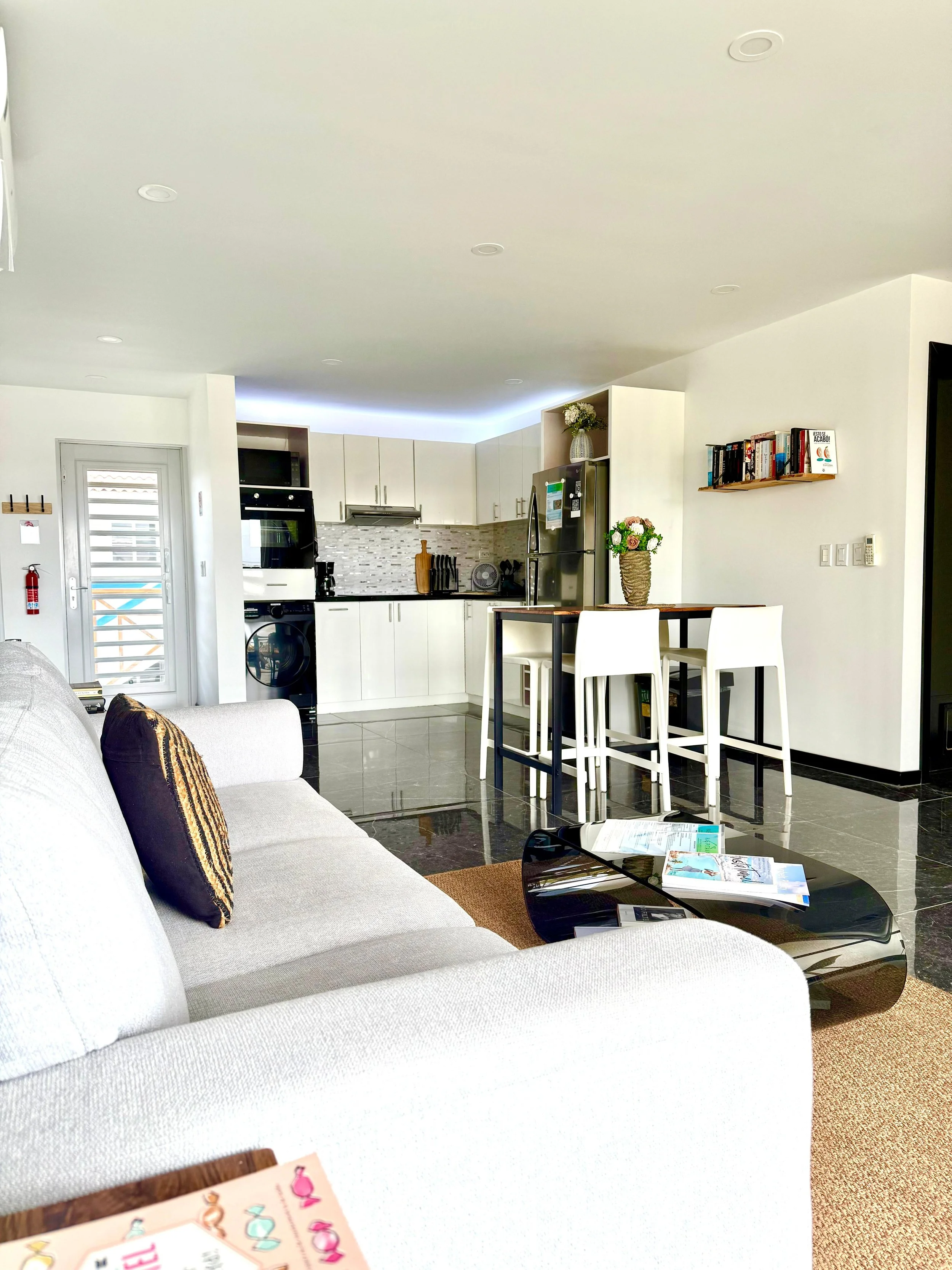 Living room at Kas Pitava with modern decor, bookshelf, and cozy white couch.