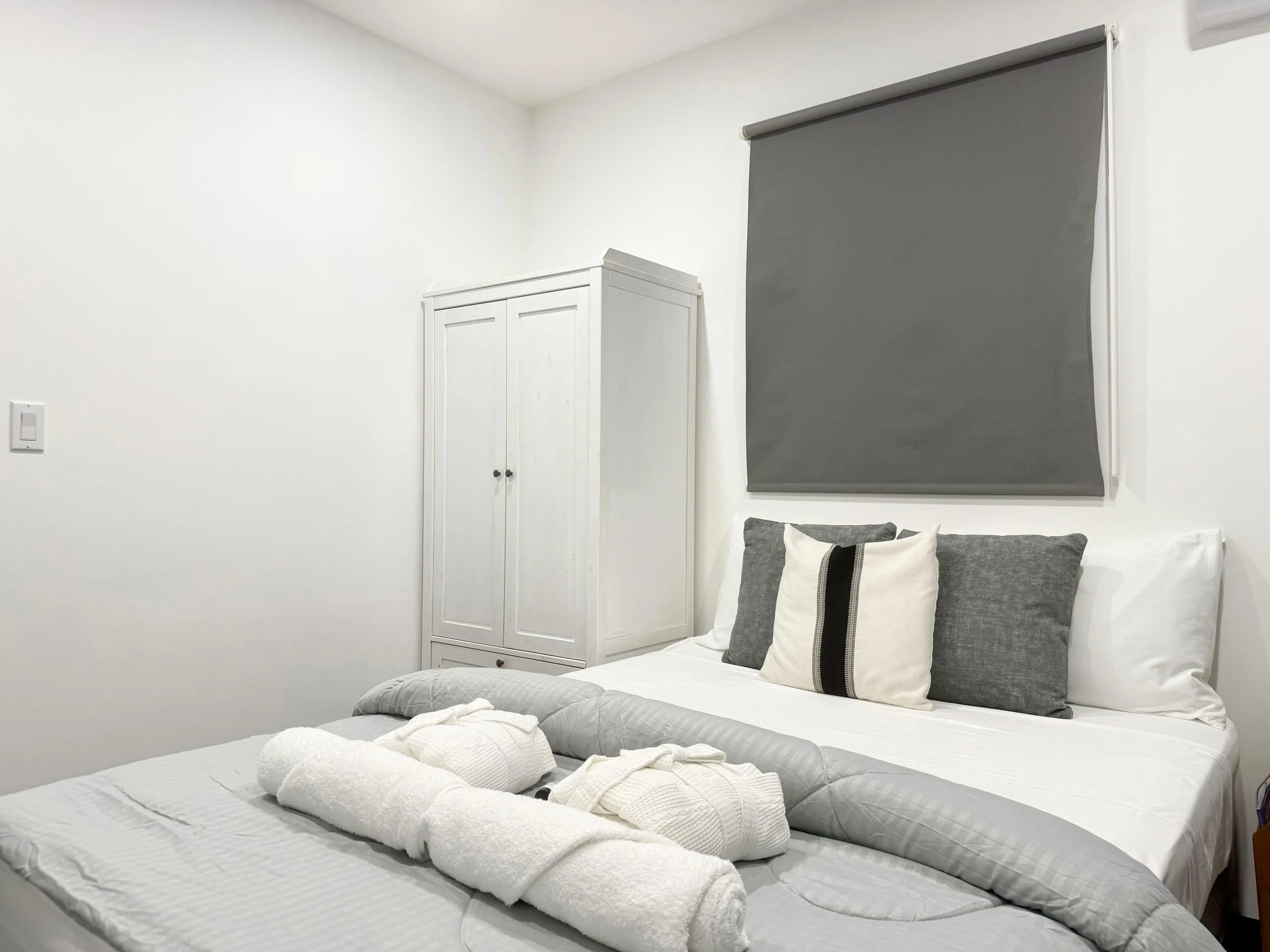 Minimalist bedroom with king-size bed and neutral-toned cushions – Kas Pitava Boutique Stay.