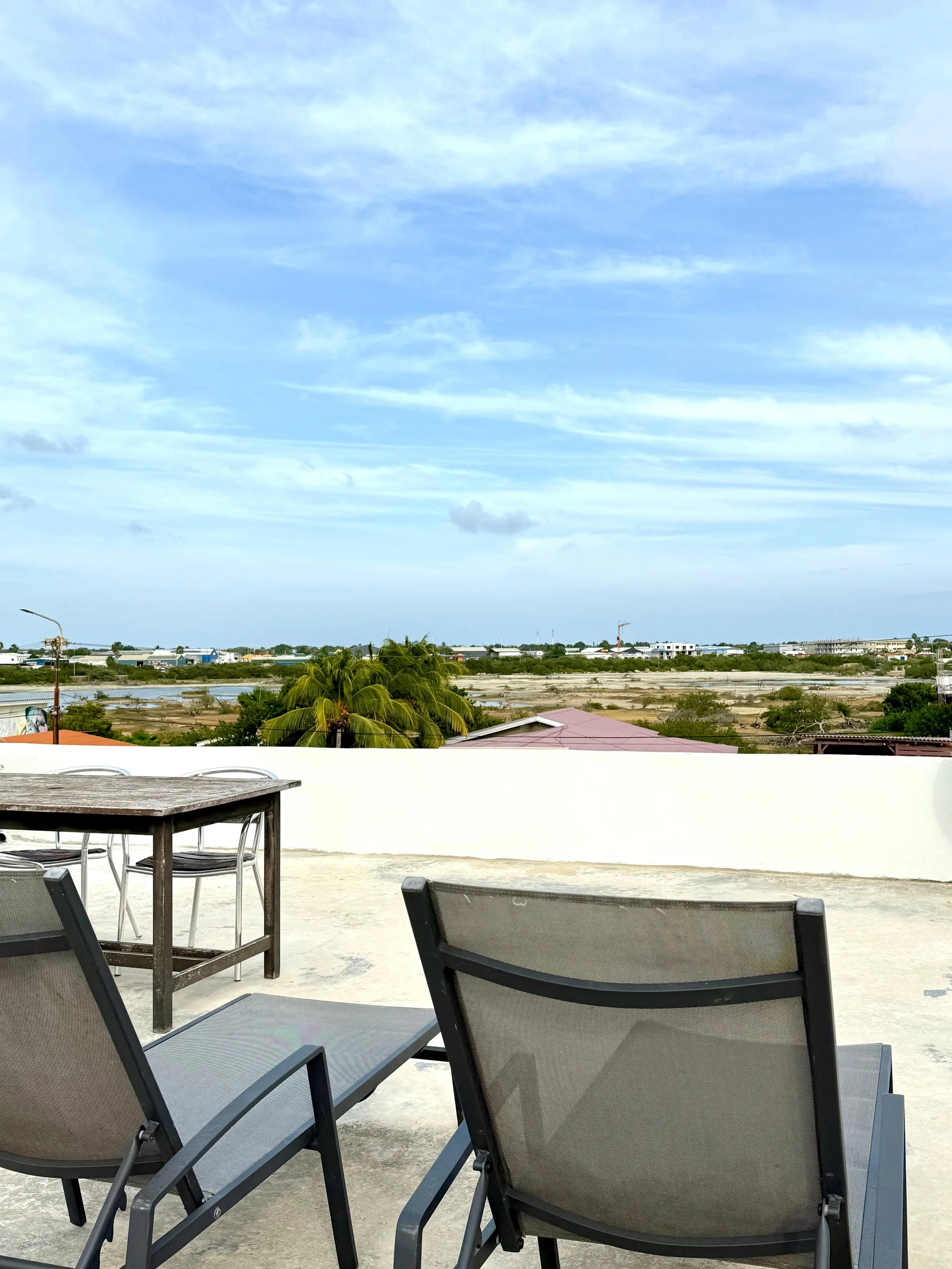 Two black terrace chairs on rooftop with nature view at Kas Pitava