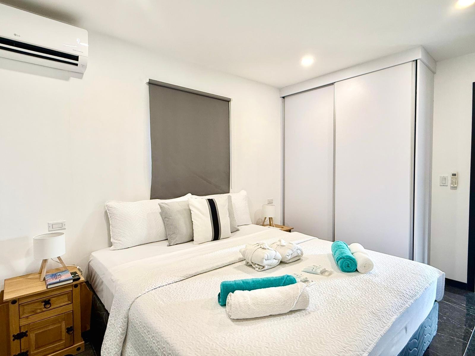 Kas Pitava, Bonaire, King-size bed with crisp white linens and elegant grey accents.