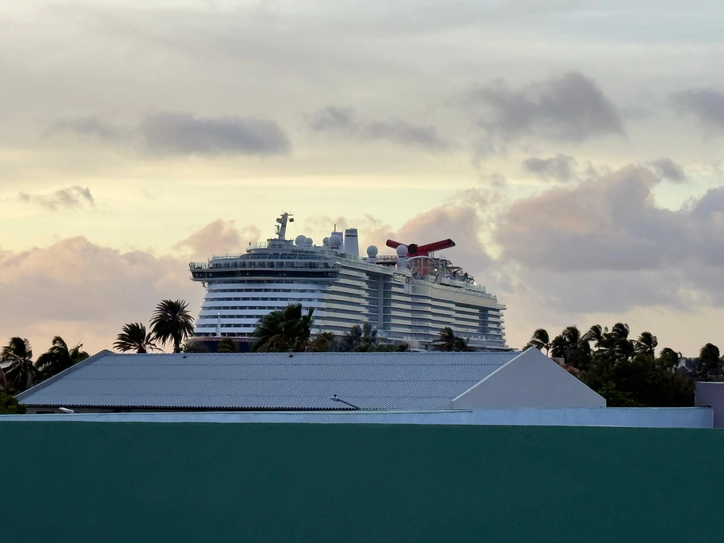 Cruise ship visible behind rooftops, dusk at Kas Pitava