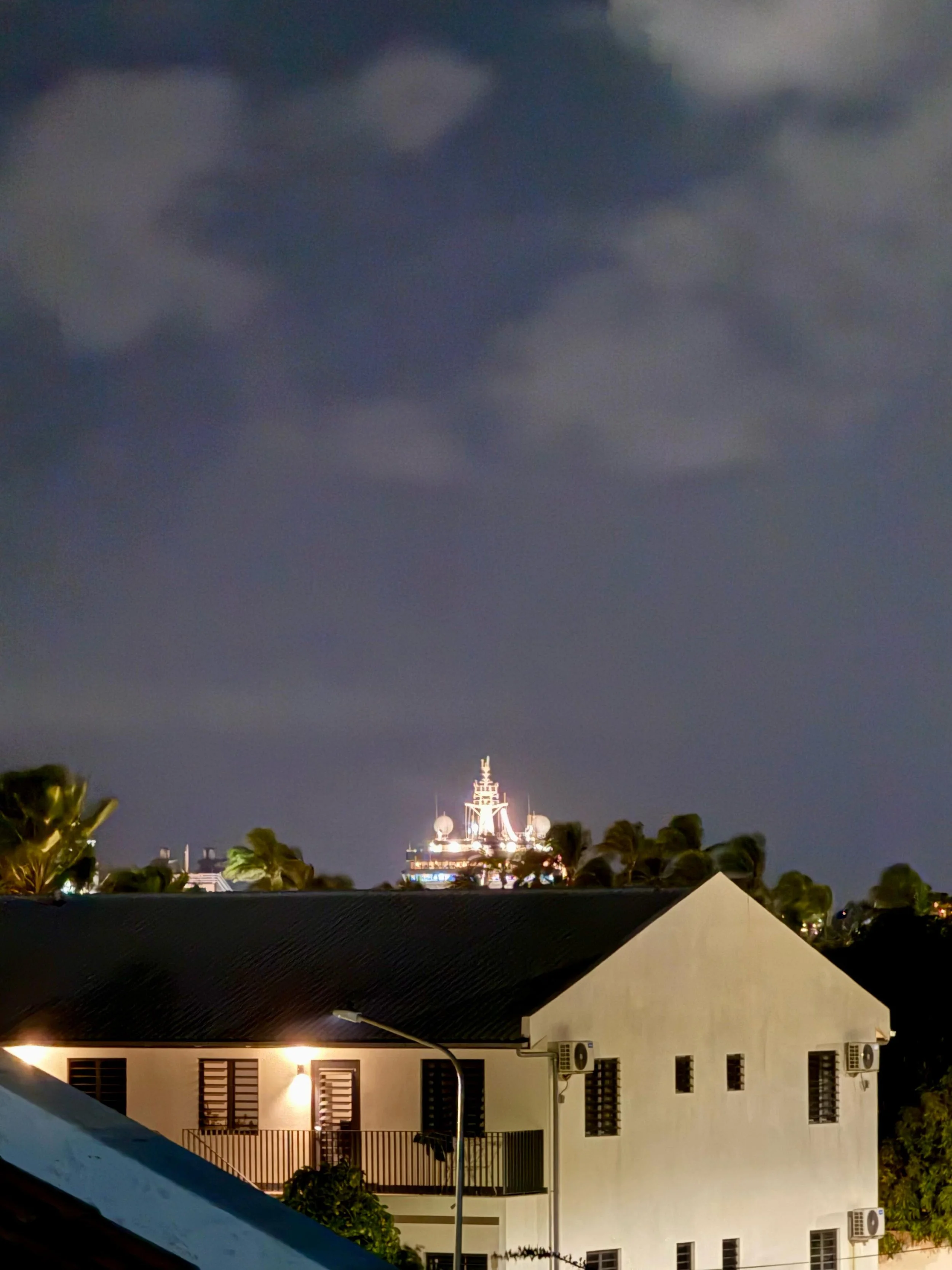 Distant view of the lit church dome under a twilight sky, seen from Kas Pitava.