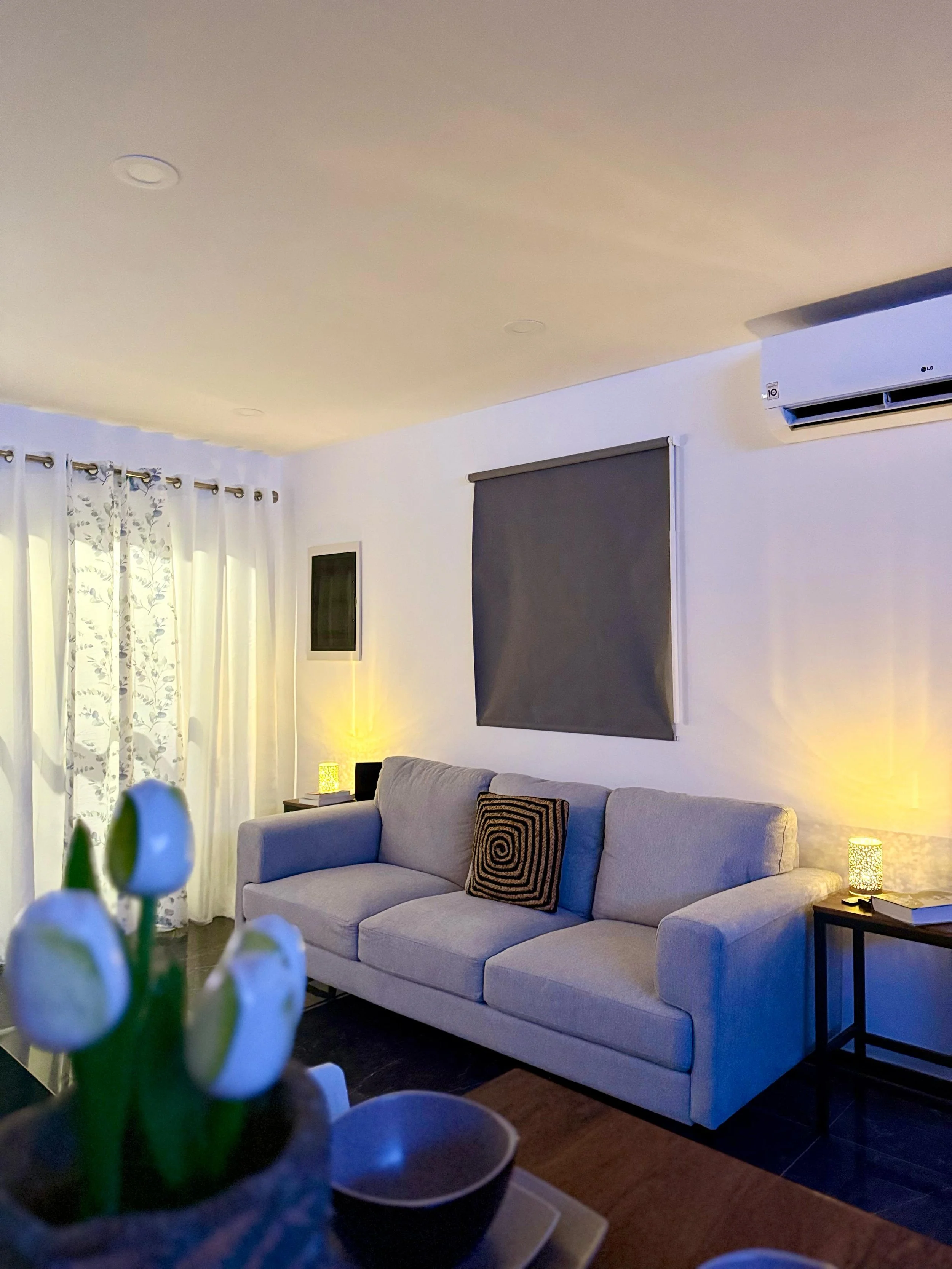 Bright lounge space at Kas Pitava with large windows and neutral-toned furnishings.