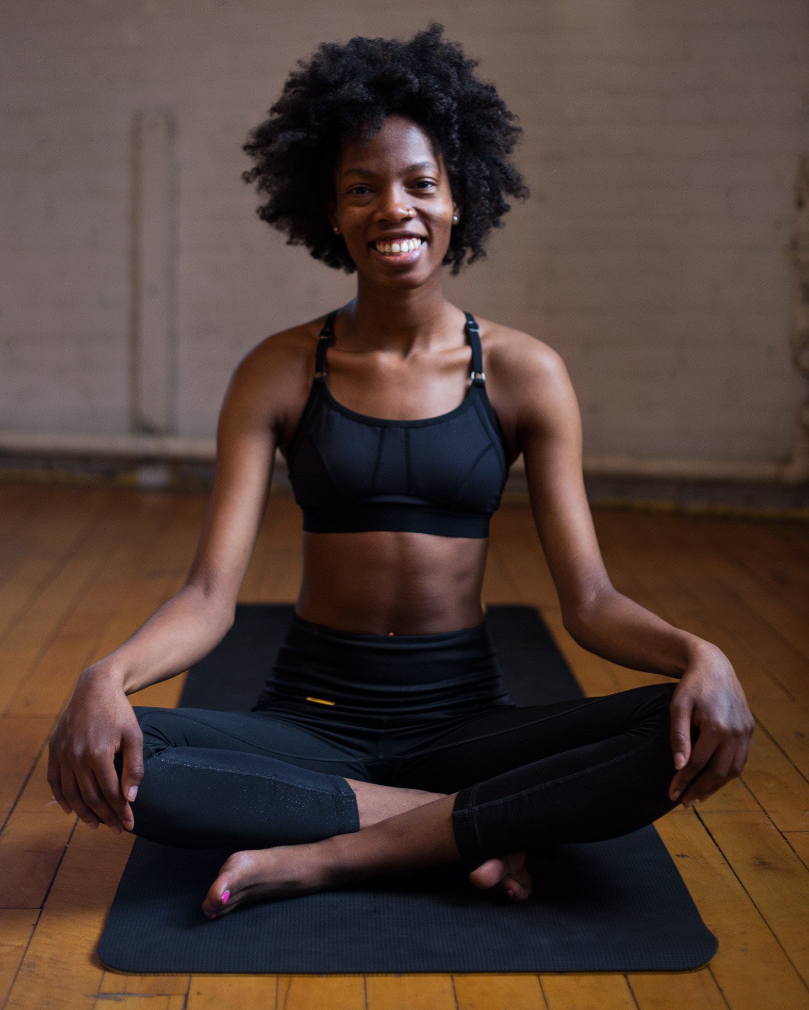 Dee sitting on a mat and smiling