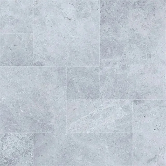 Tundra Grey is a light gray marble with darker swirls and lighter-gray veining. Shown in a French Pattern with a sandblasted texture for slip resistance.