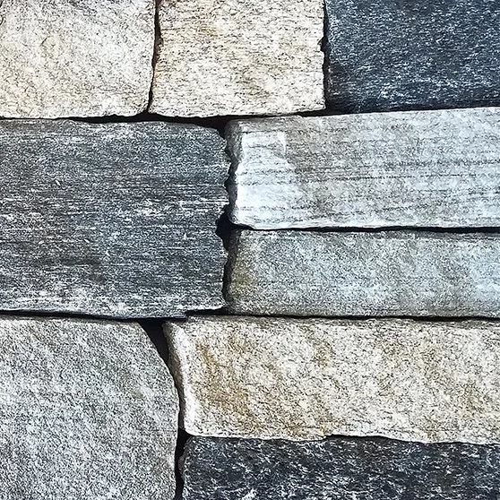 Natural stone veneer blending dark gray, light gray and a little bit of white, comparable to the Boston blend of stone common in the northeast.  Shown in a natural ledgestone configuration.
