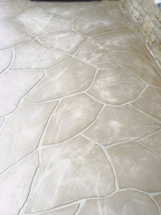 Concrete floor with irregular, leaf-shaped pattern and grout lines.