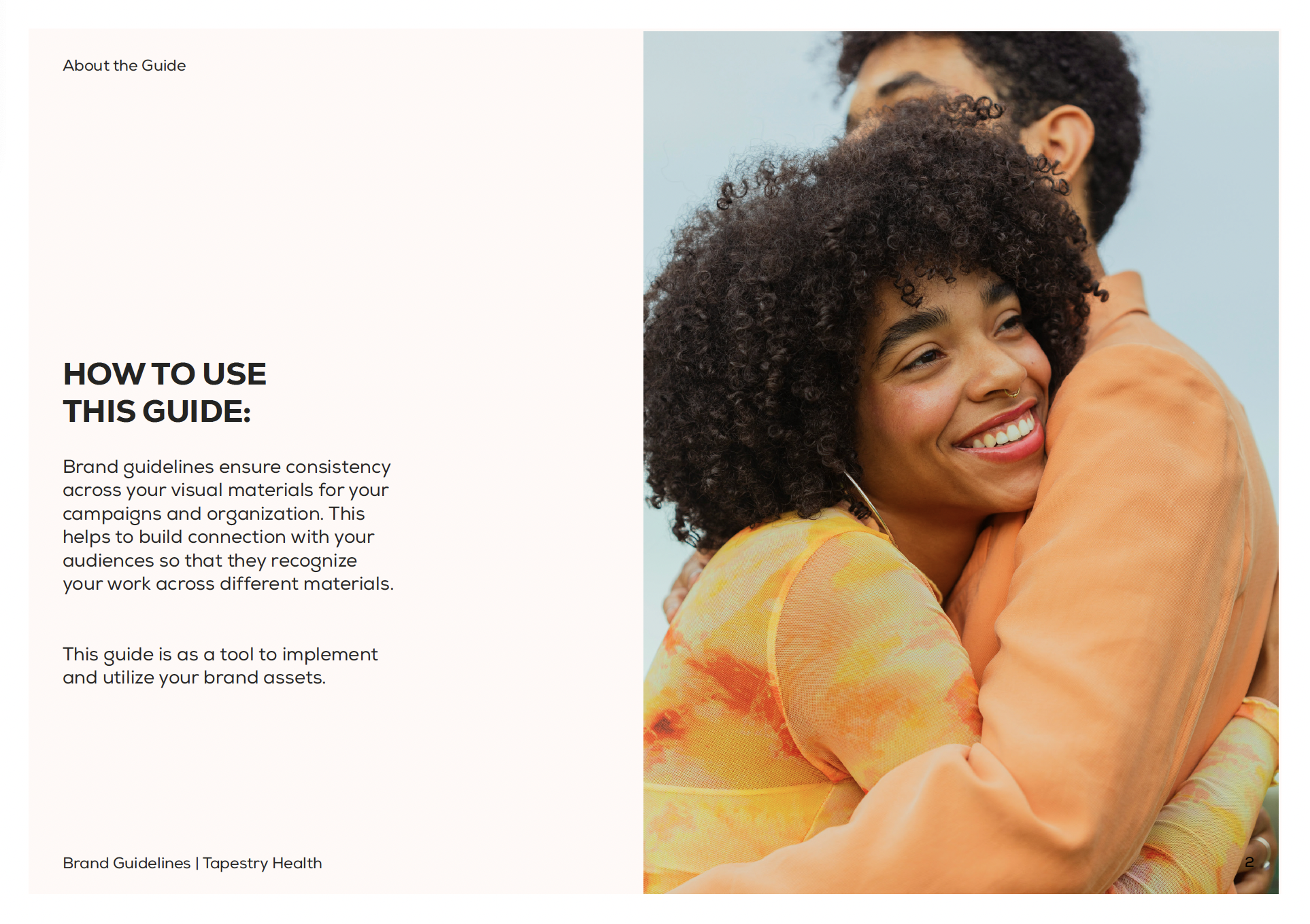 A smiling woman hugging a man outdoors against a clear sky, both wearing orange clothing.