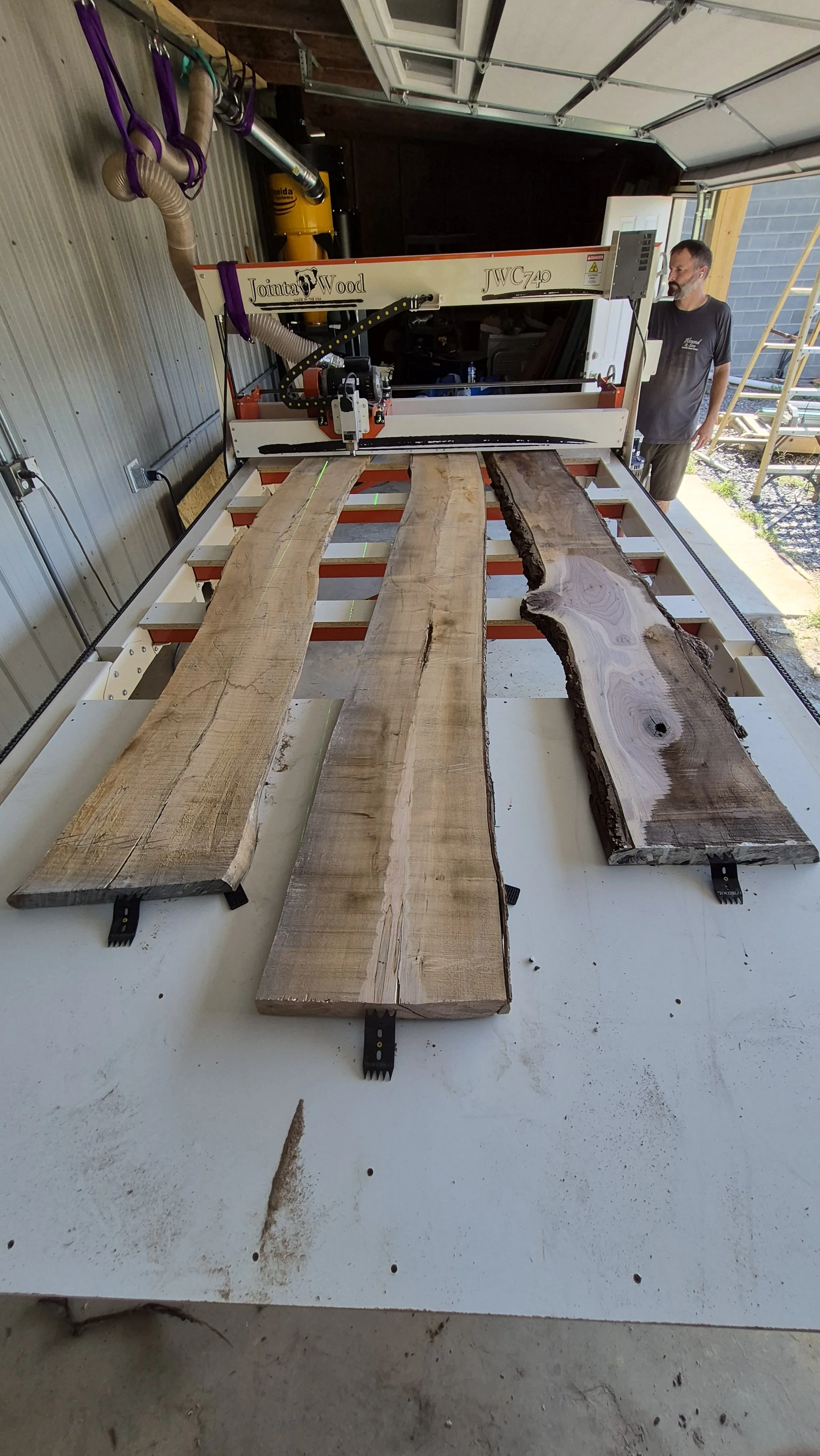 Three live edge wood slabs laid out for selection in the Live Edge Exclusives shop in Locust, NC