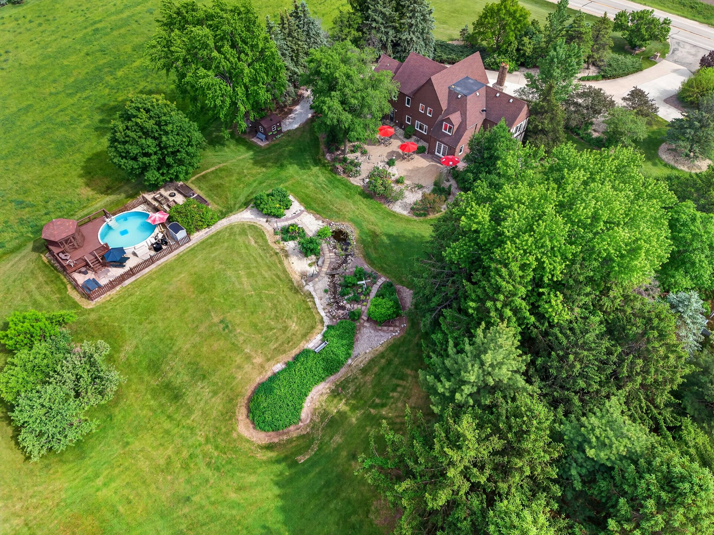 Aerial drone photography for real estate listing with huge backyard with beautiful landscaping and pool in southeastern wisconsin