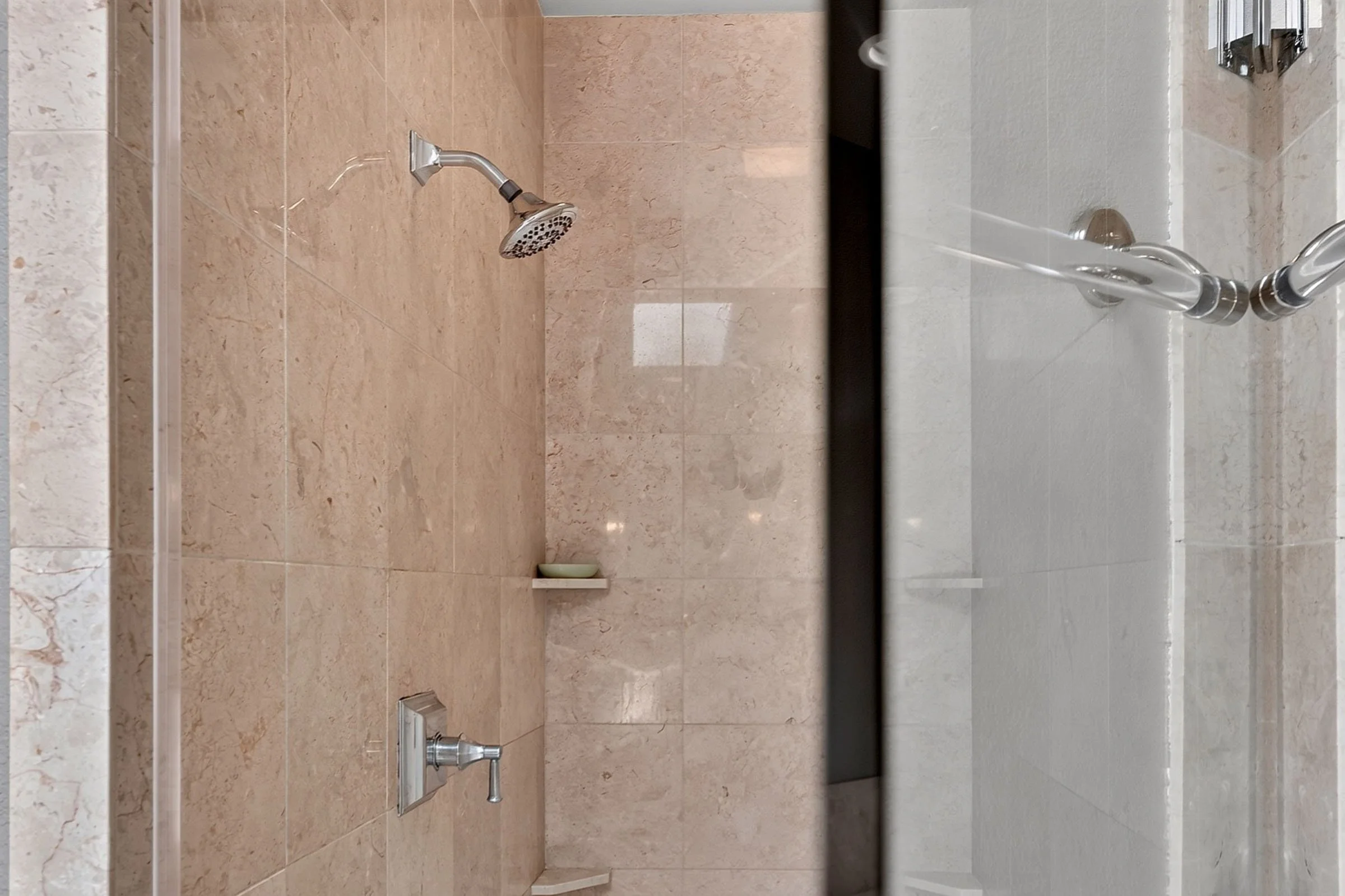 Detail shot of a luxury shower with high-end tiling - photo credit to brandon henning with dream home real estate media