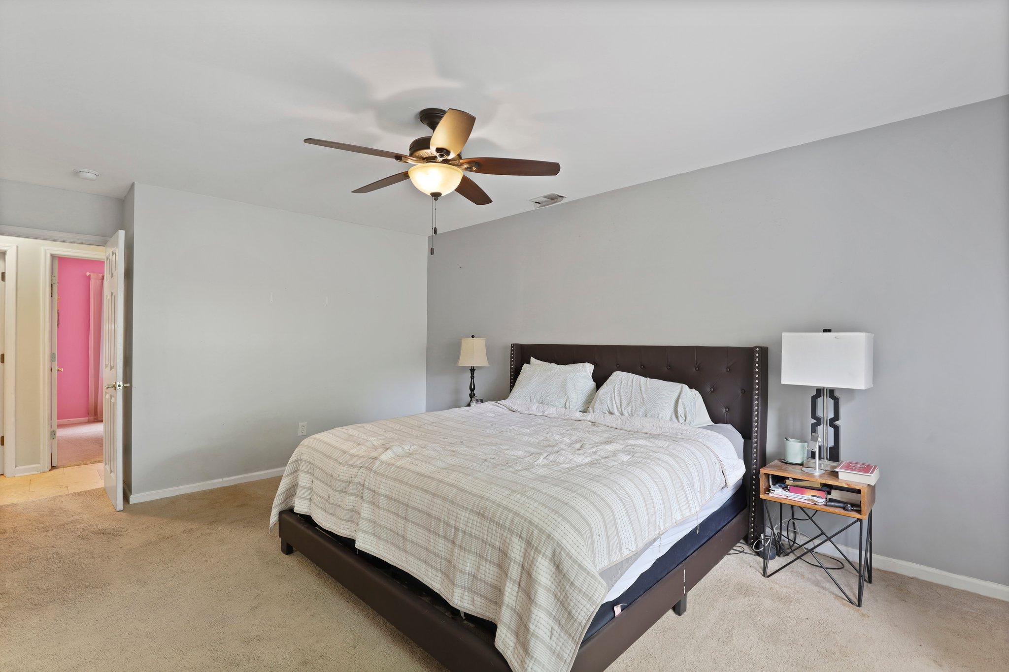 Bedroom with a ceiling fan and a large bed.