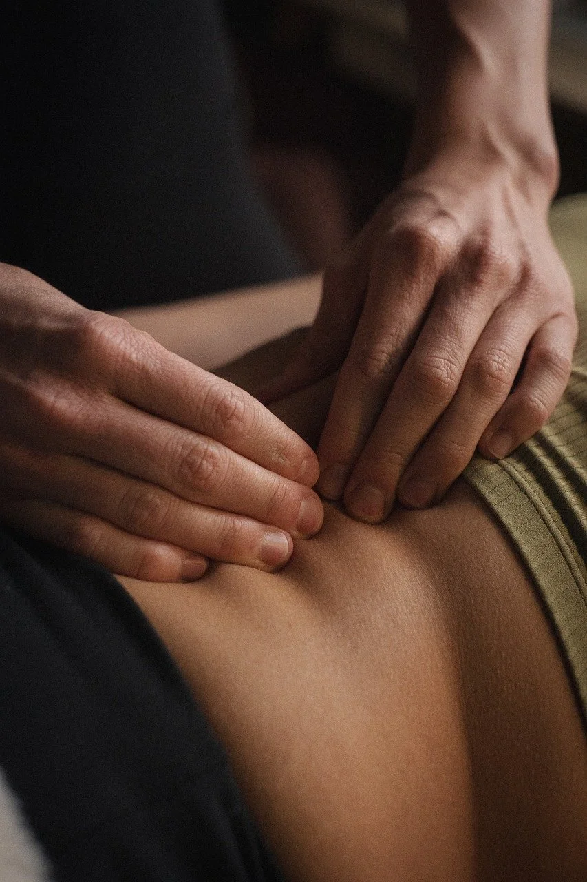 Close-up of hands pressing on a person's shoulder or back.