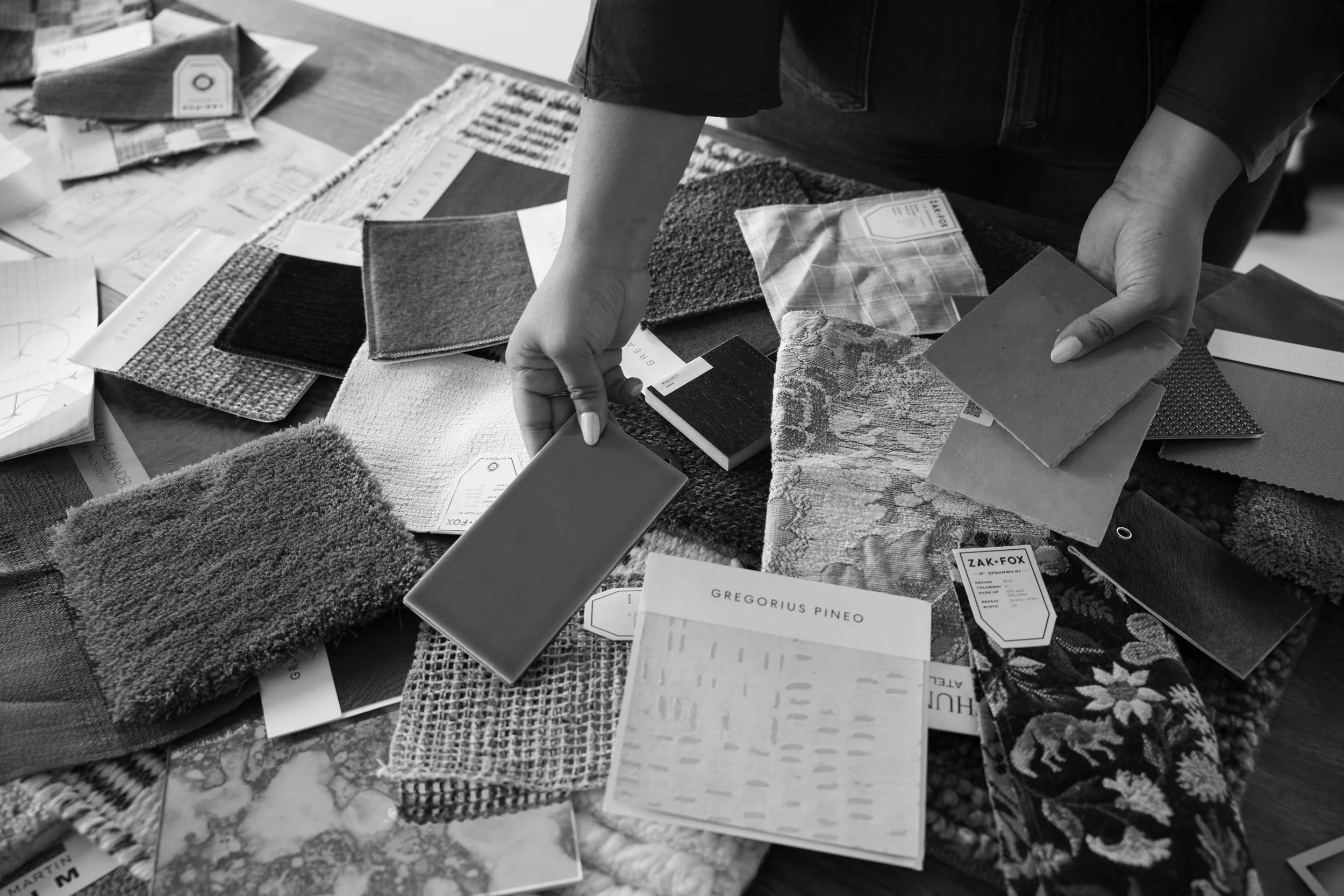 Review of luxury fabric swatches and textile samples for custom interior design project.