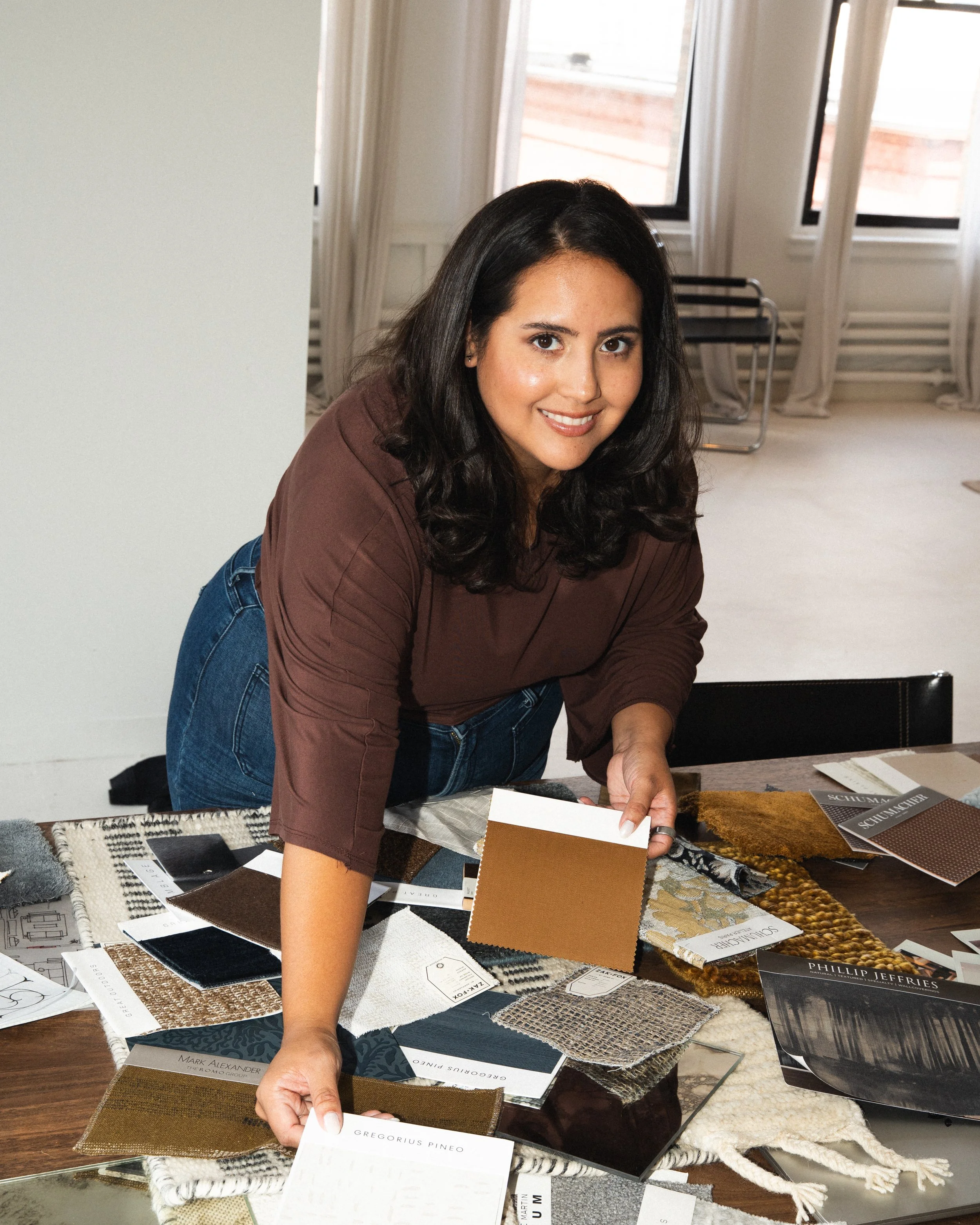 Boston interior designer selecting fabric swatches and finish samples for a luxury residential project.