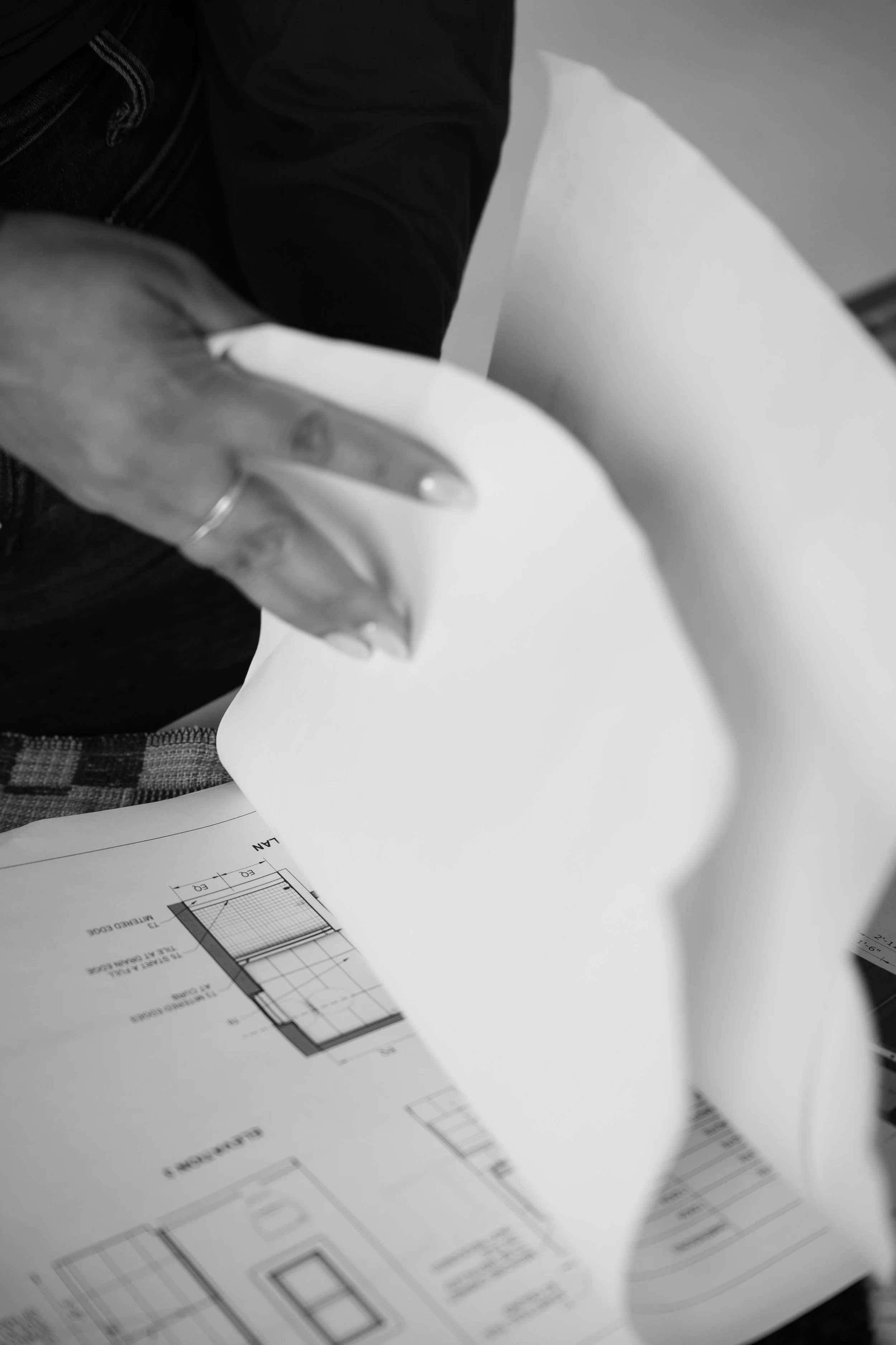 Interior designer reviewing custom architectural blueprints and space plans for a residential design client.