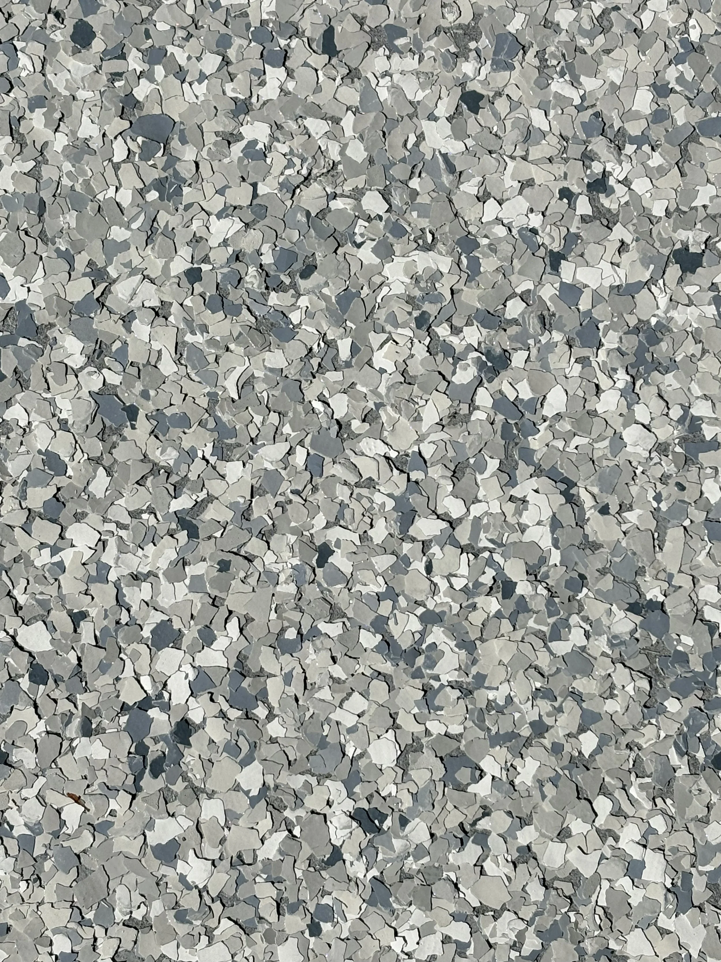 Close-up view of a textured surface with small, irregularly shaped gray and white particles