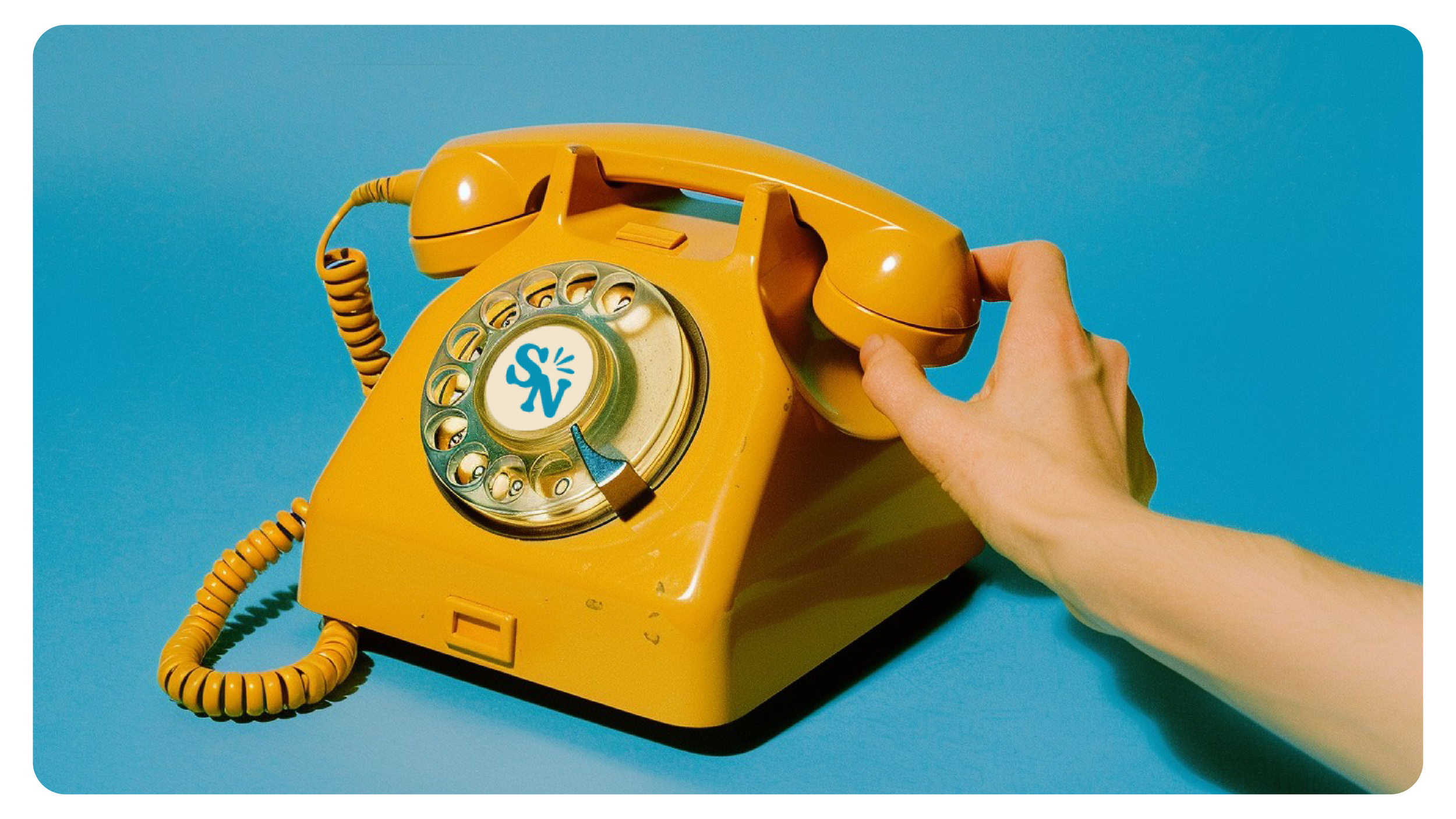 A vintage yellow rotary telephone on a blue background, with a hand pressing the receiver.