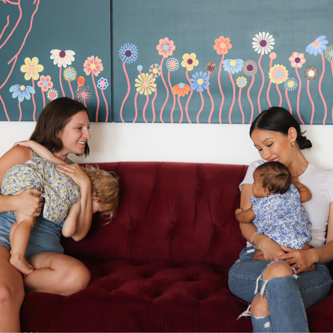 two moms holding babies