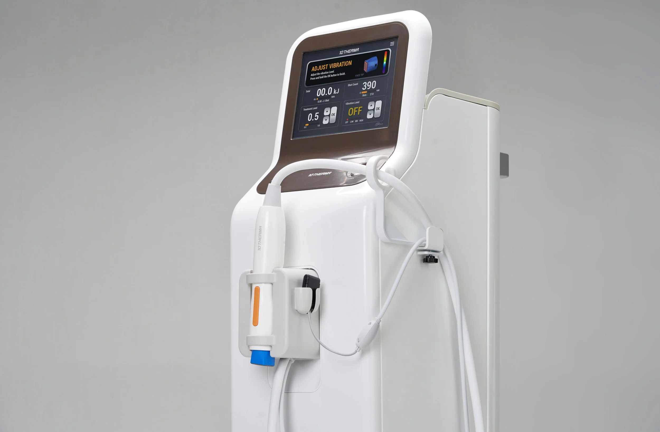 Medical device called 10 Therma with digital screen and attached handheld probe, used for therapeutic or diagnostic purposes.