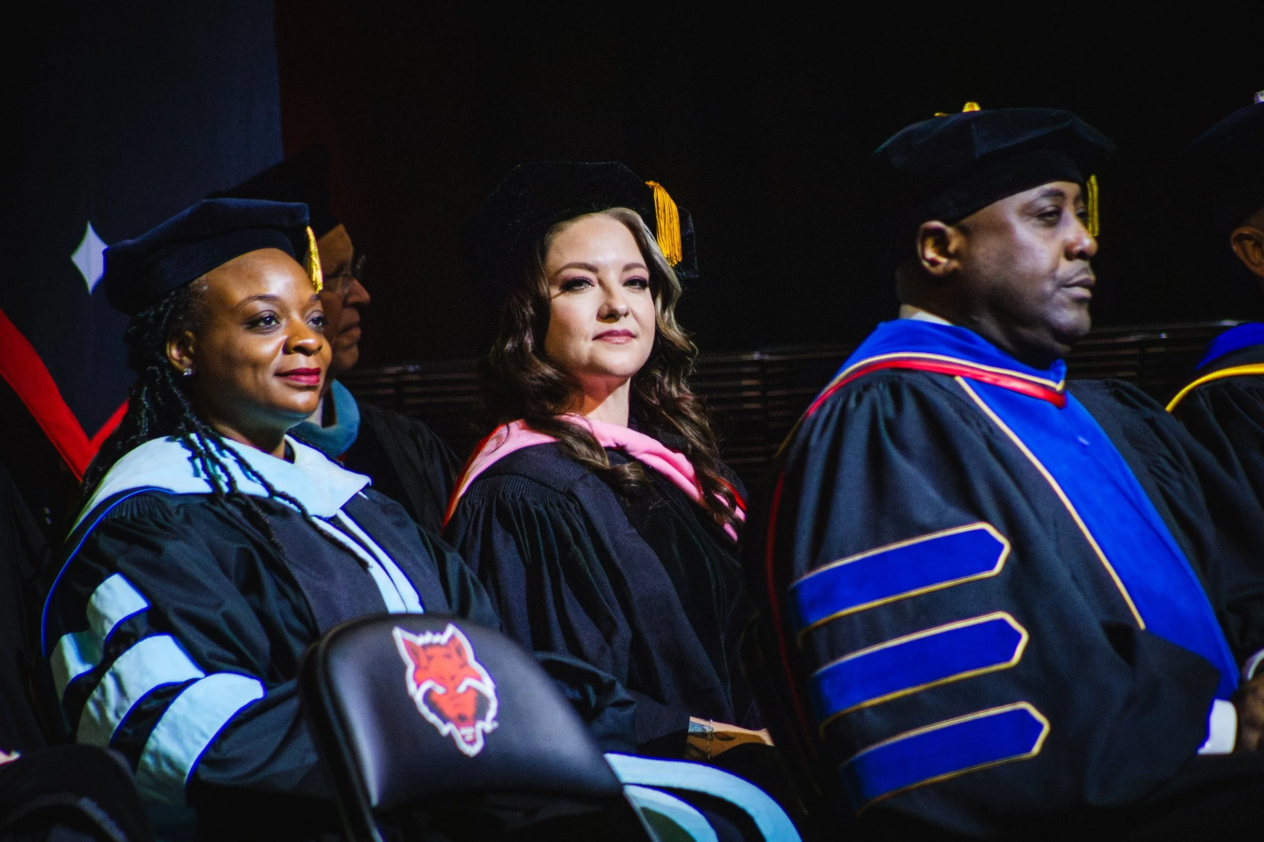 Ashley McBryde and a Group of graduates in academic regalia seated during the Arkansas State University spring 2025 commencement ceremony.