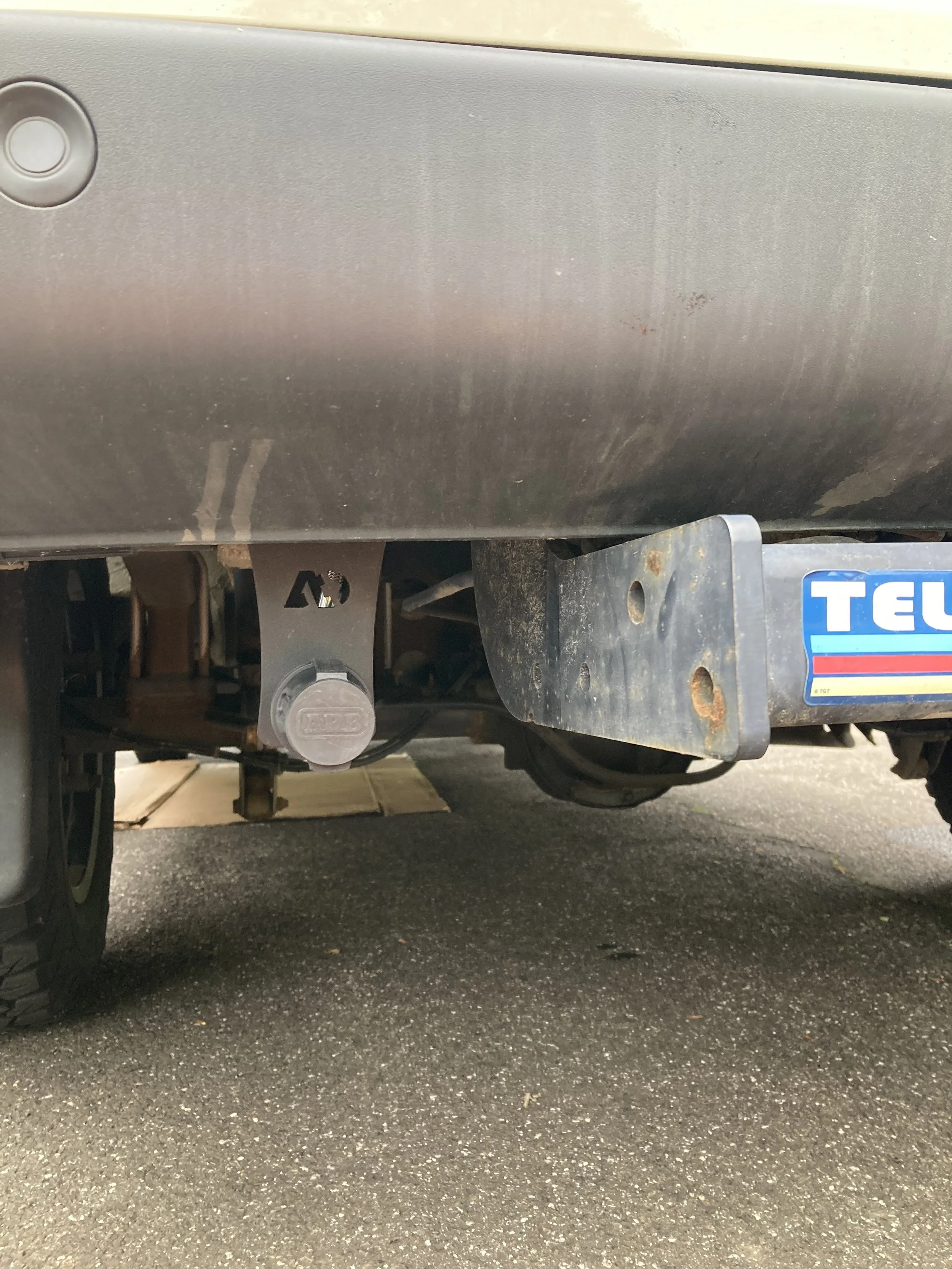 Air port mounted by trailer hitch for easy inflation for rear tires