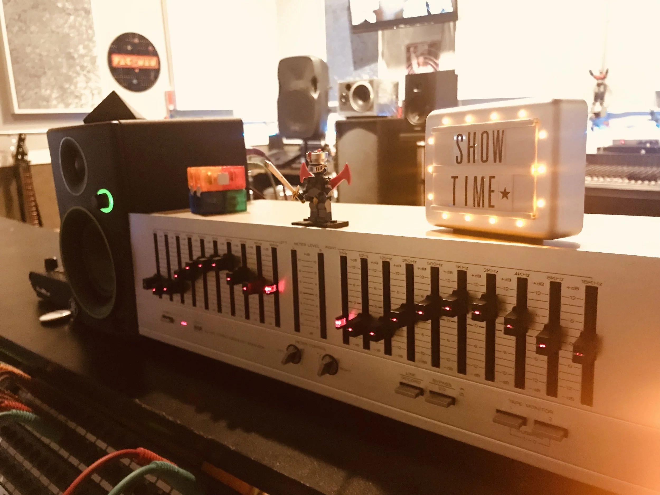 Snow-capped mountains with a small building on green hills.