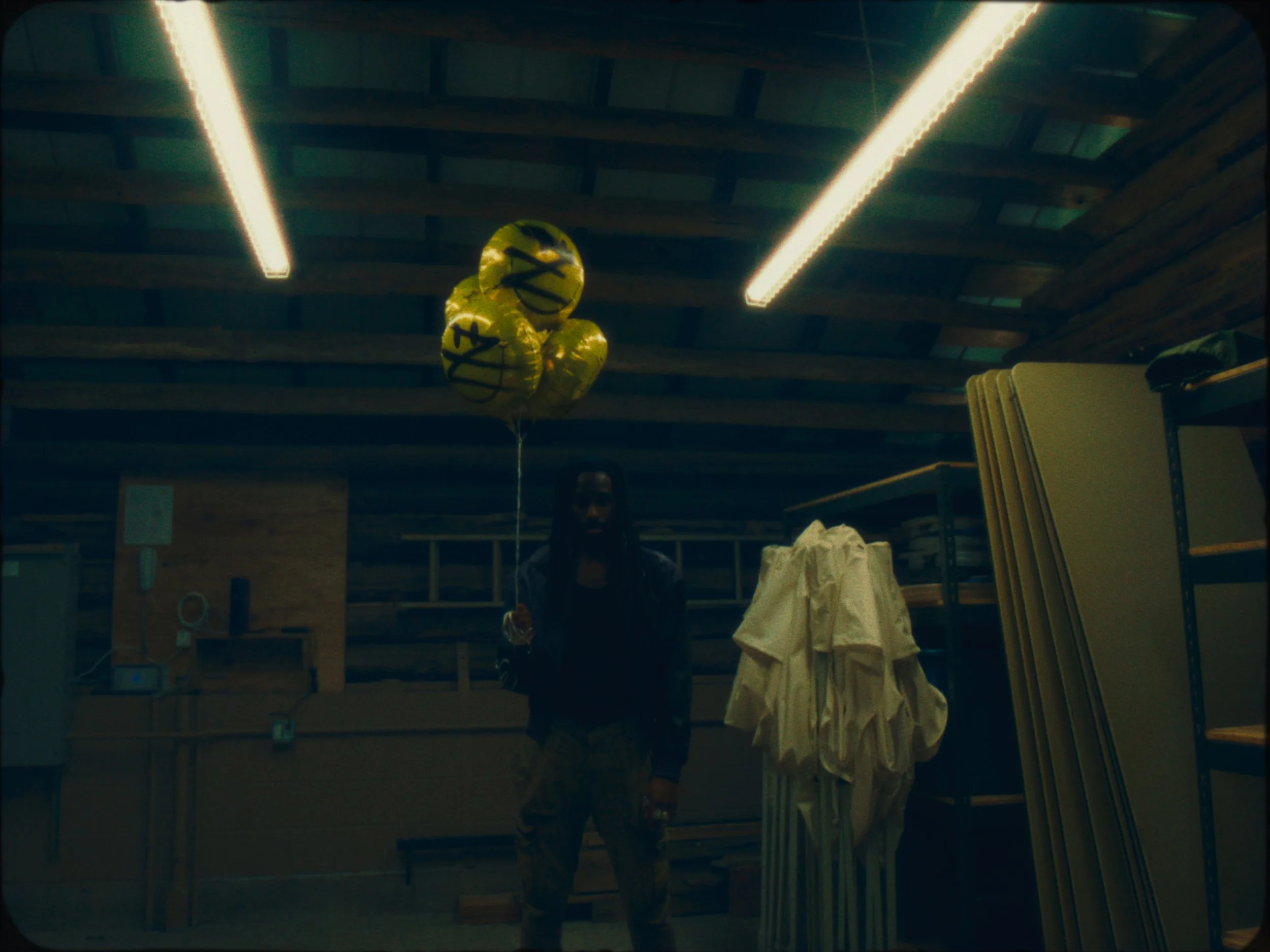 A person standing in a store or warehouse with yellow balloons and store shelves.