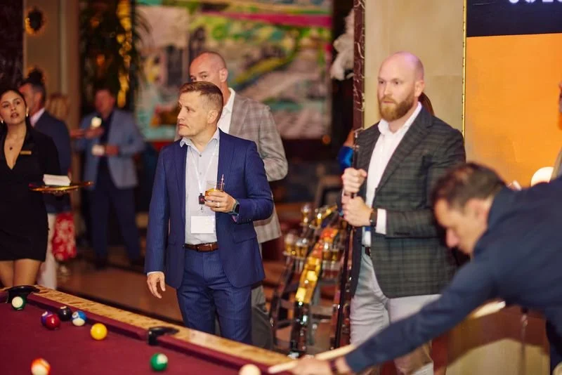 People playing billiards at a social event or party in a decorated venue.