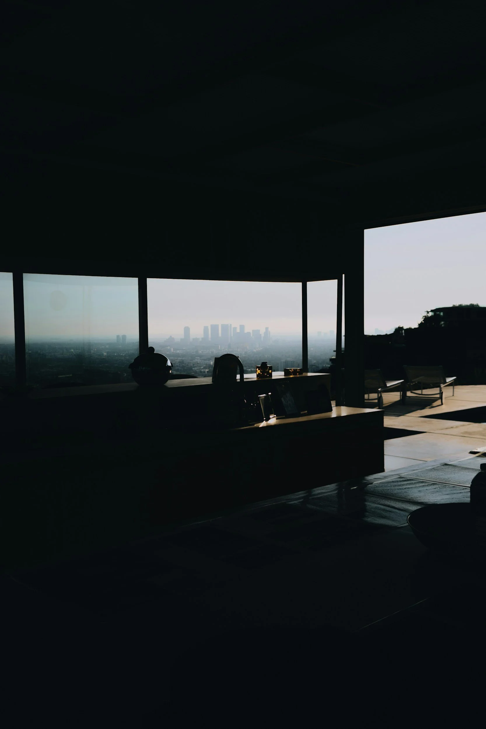 Interior of a modern high-rise apartment with large windows offering a cityscape view.