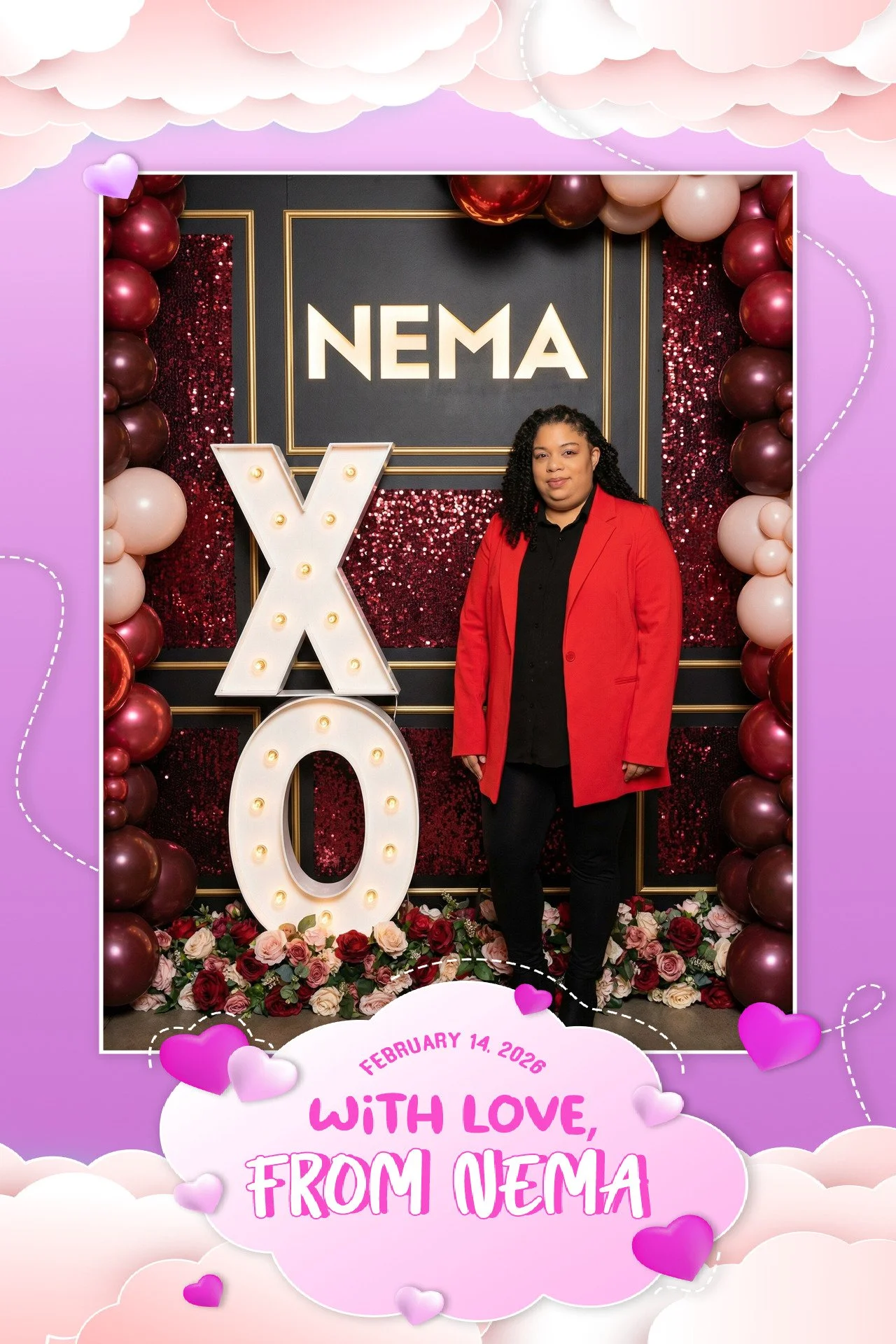 A woman in a red blazer standing in front of a Valentine's Day display with the words 'NEMA' and 'X O'. The setting includes balloons and roses, with a pink and purple cloud-themed border and hearts, and a message that reads, 'February 14, 2026, With